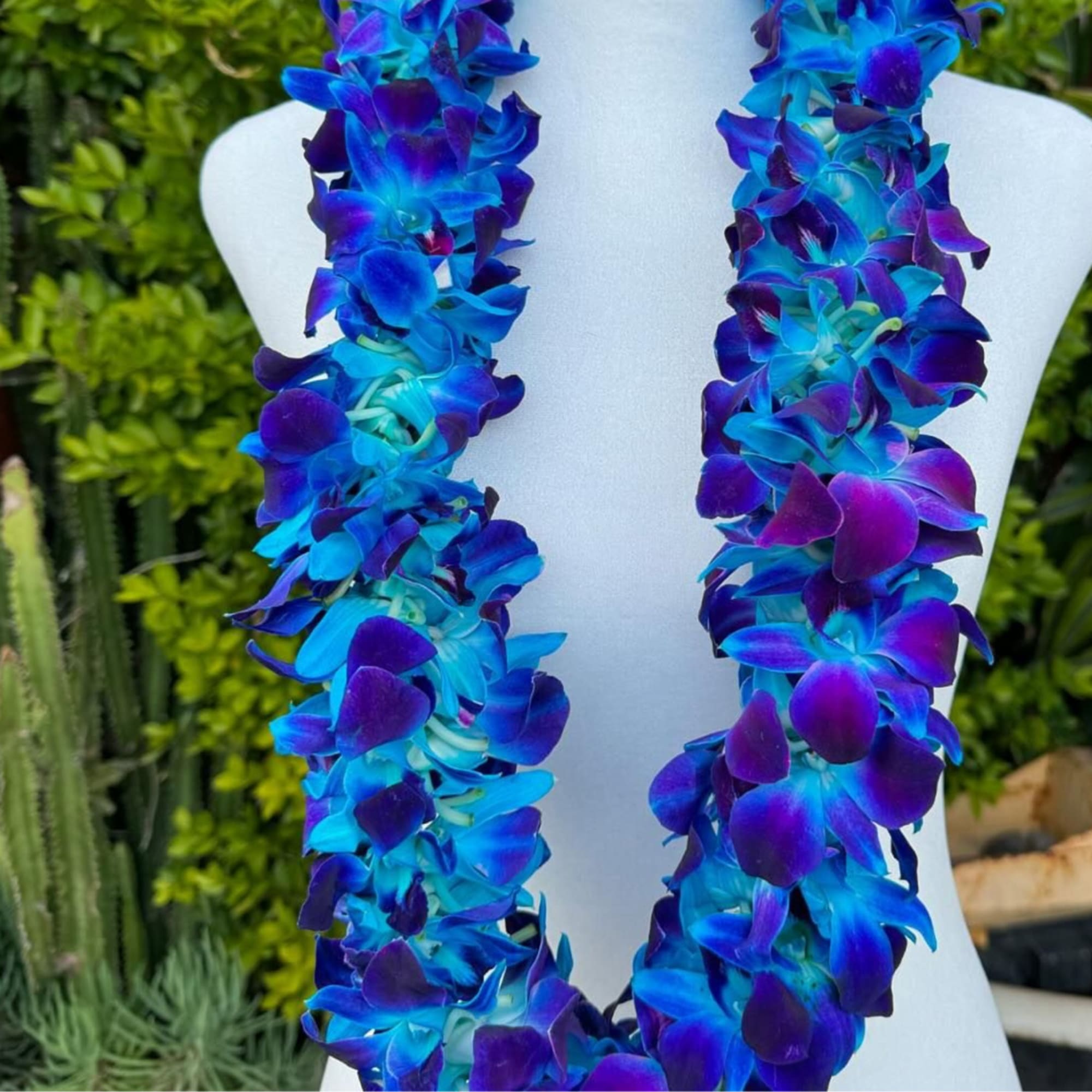 Electric-blue orchid leis that read like a bold island celebration - perfect