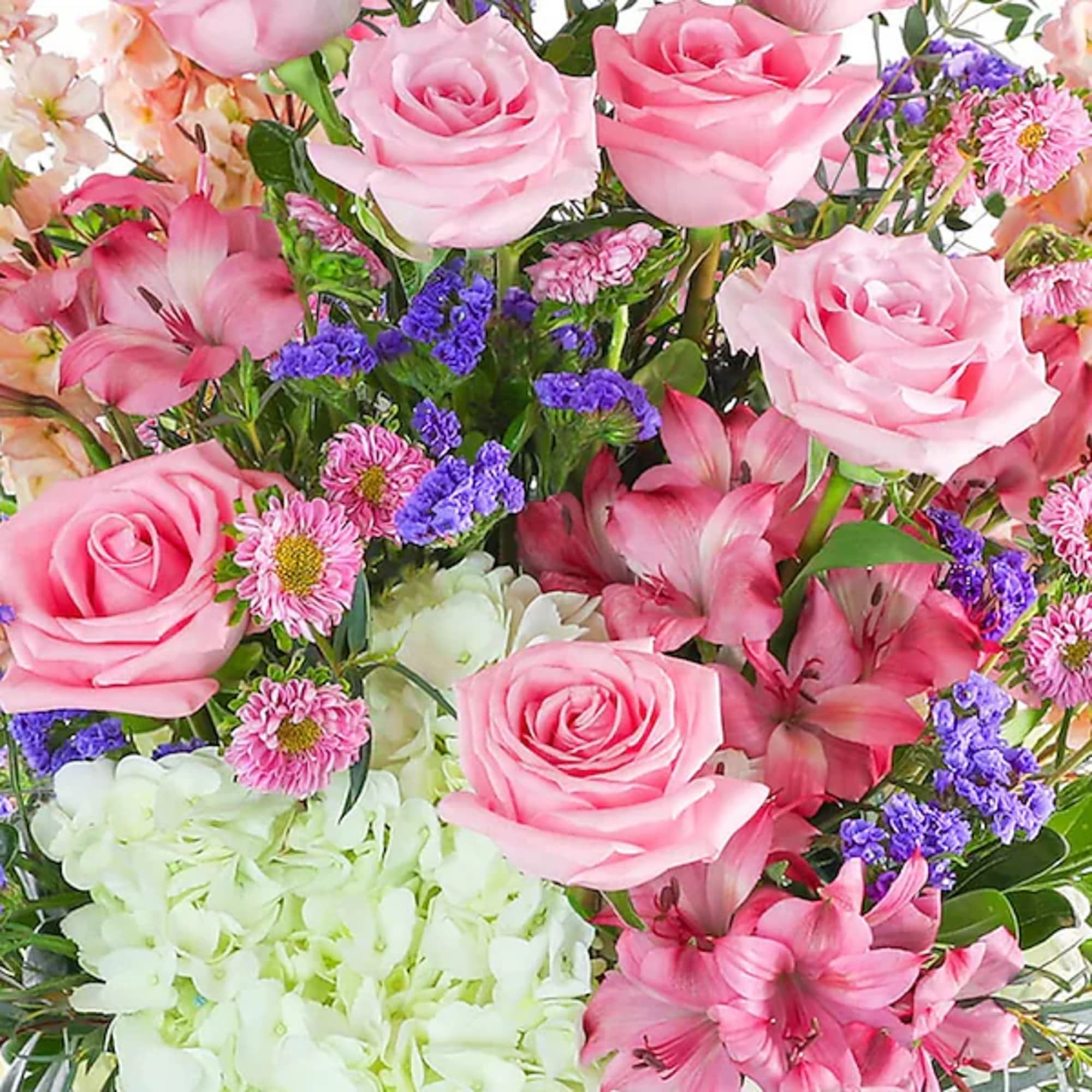 Bouquet of pink roses, lilies, and hydrangeas with purple filler flowers