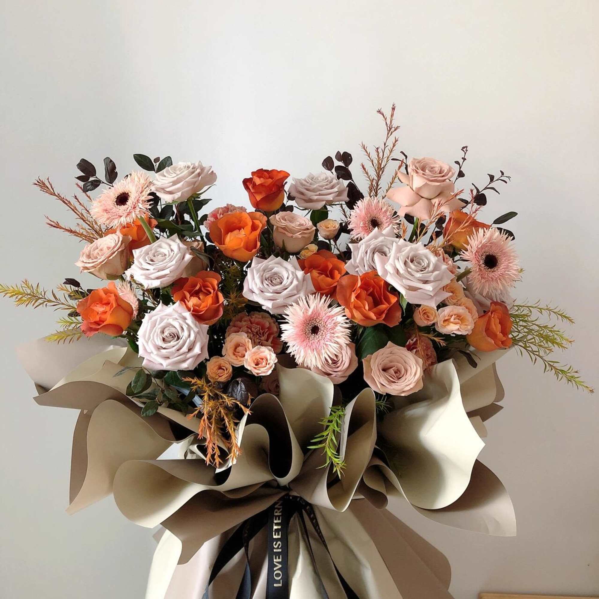 Large bouquet of peach and white roses with pink gerbera daisies