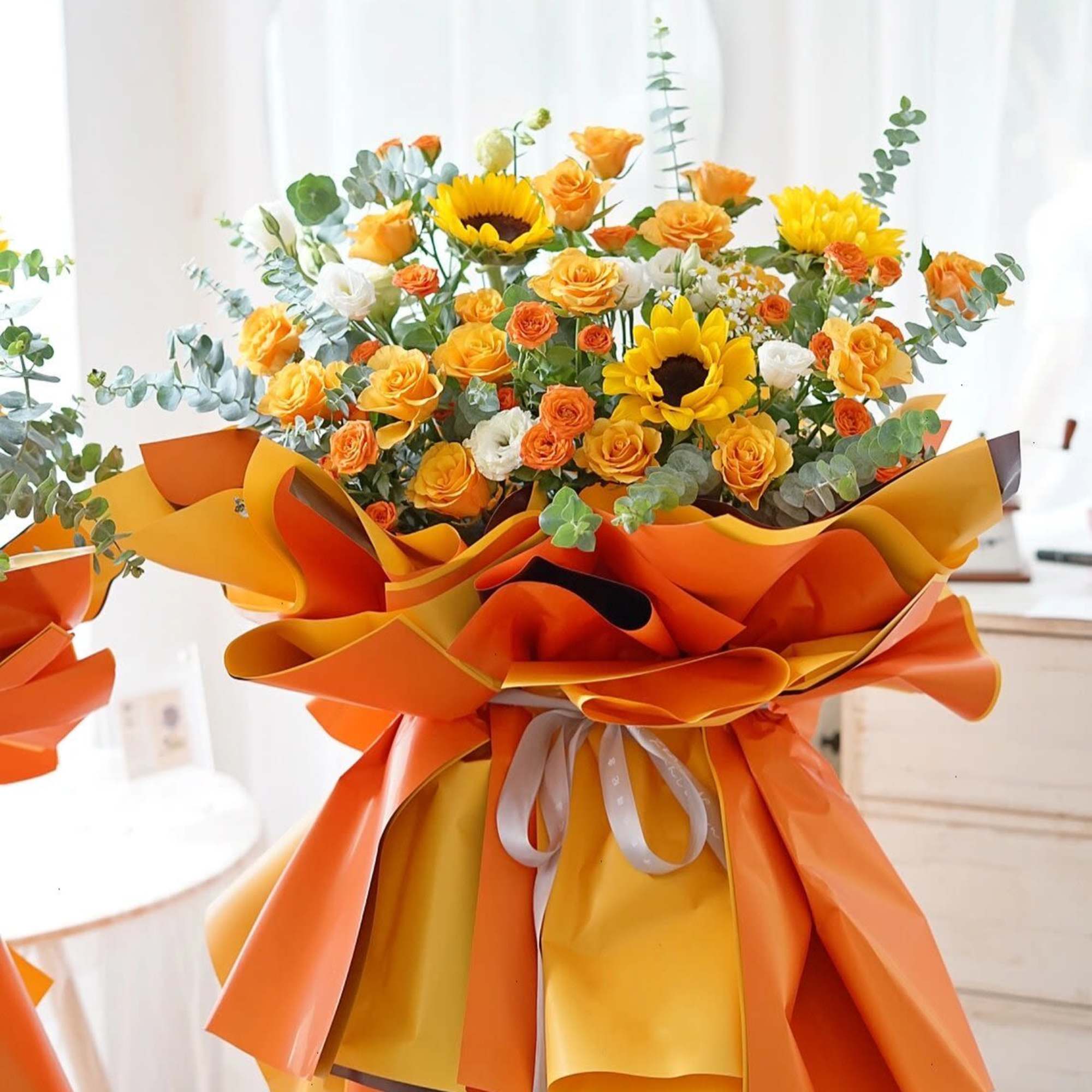 Bouquet of yellow and orange flowers wrapped in bright orange paper