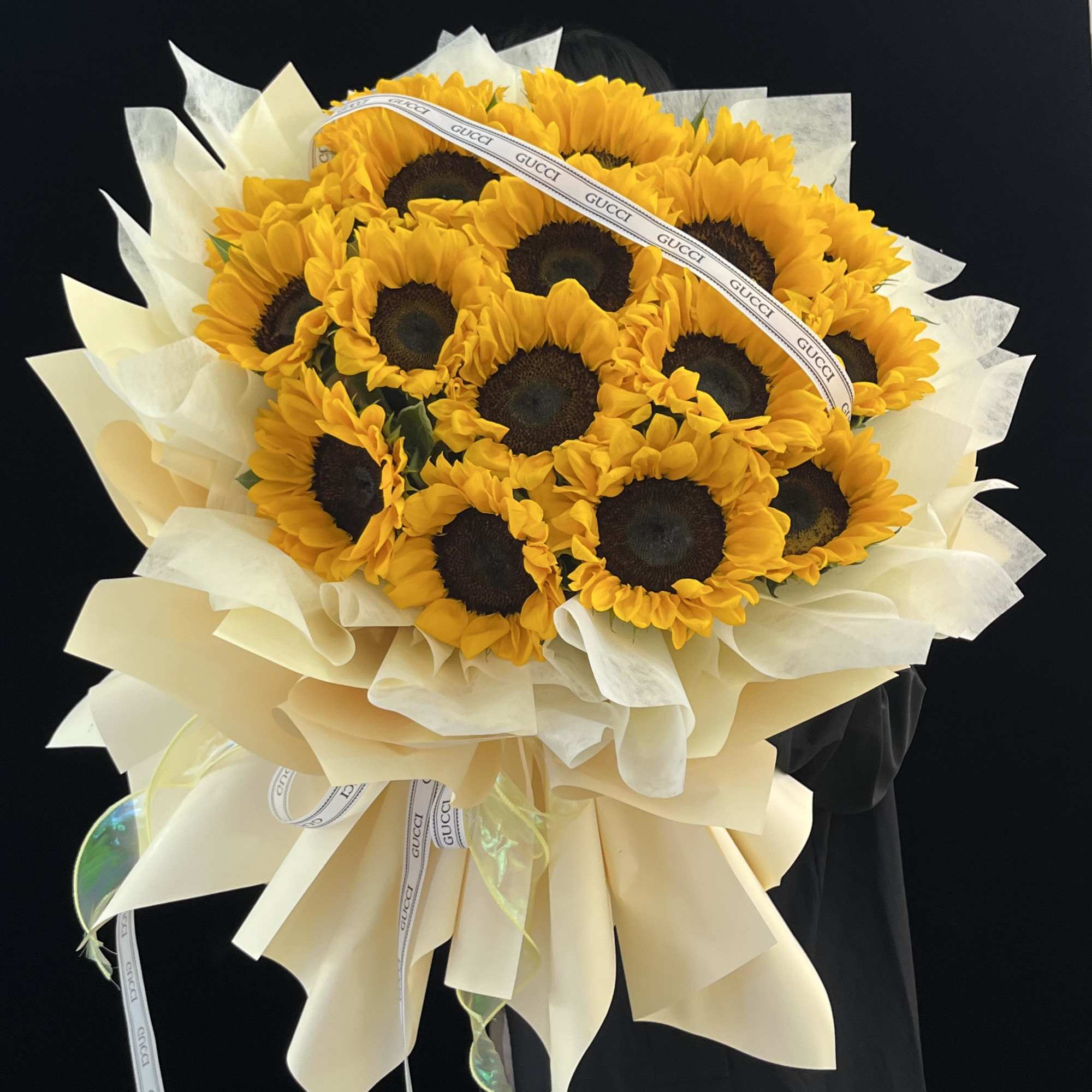 Bouquet of sunflowers wrapped in cream paper with a ribbon
