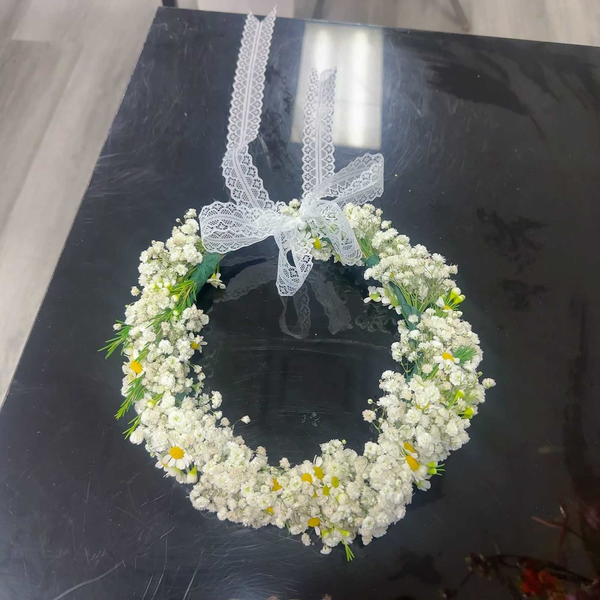 White floral wreath with a lace ribbon bow