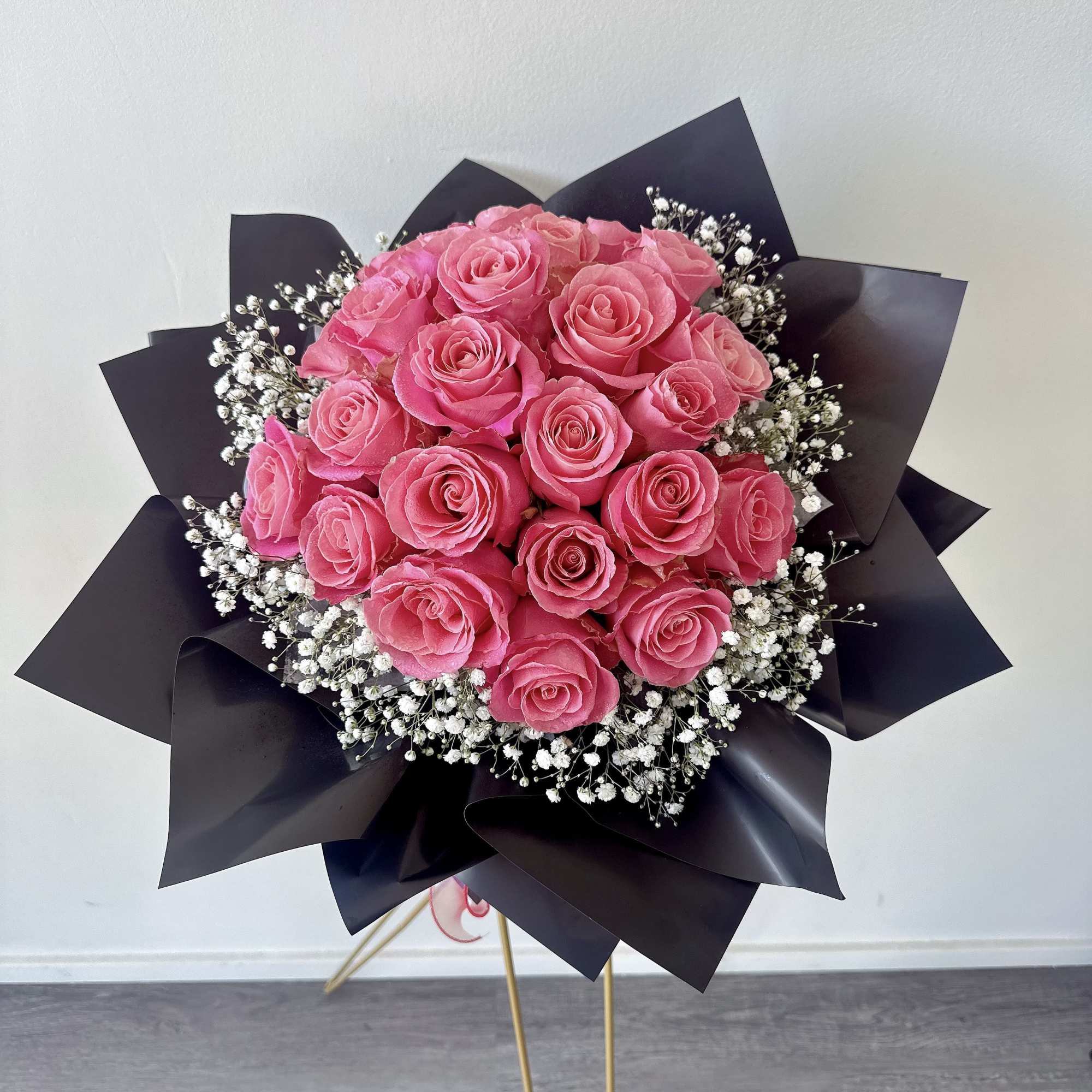 Bouquet of pink roses with white baby's breath in black wrap, photo 2 of 2