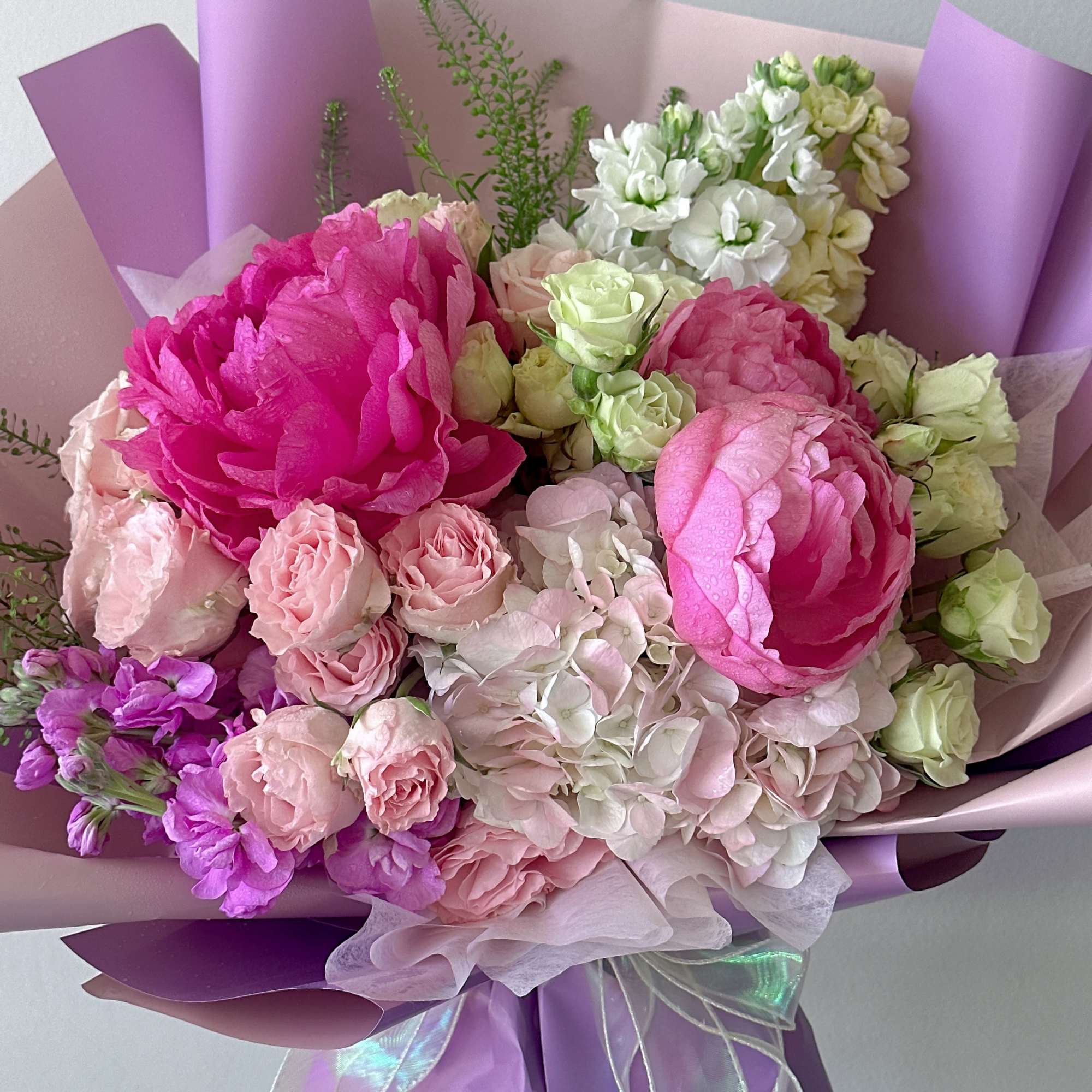 Bouquet of pink and white flowers wrapped in lavender paper, photo 2 of 3