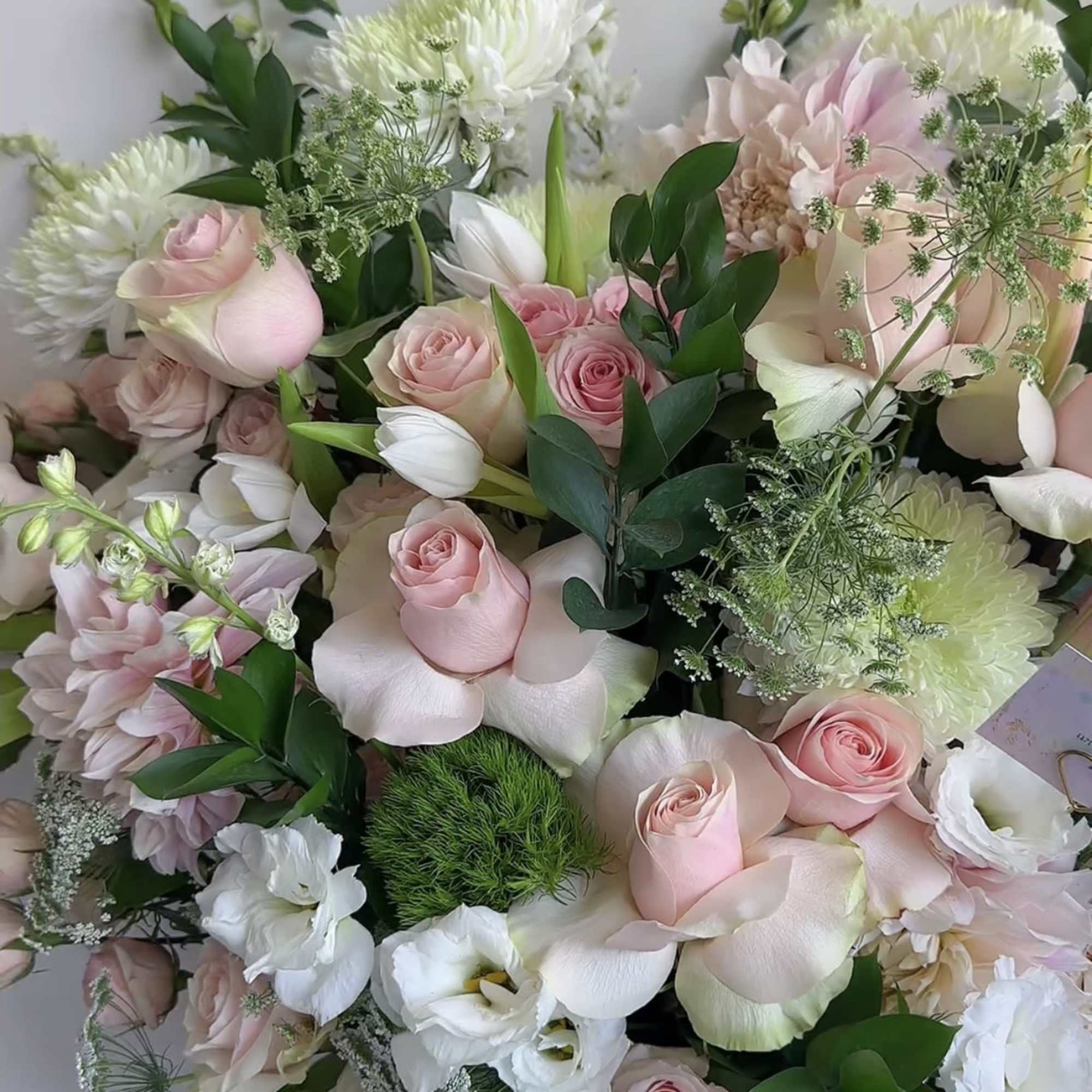 Bouquet of pale pink and white flowers with greenery