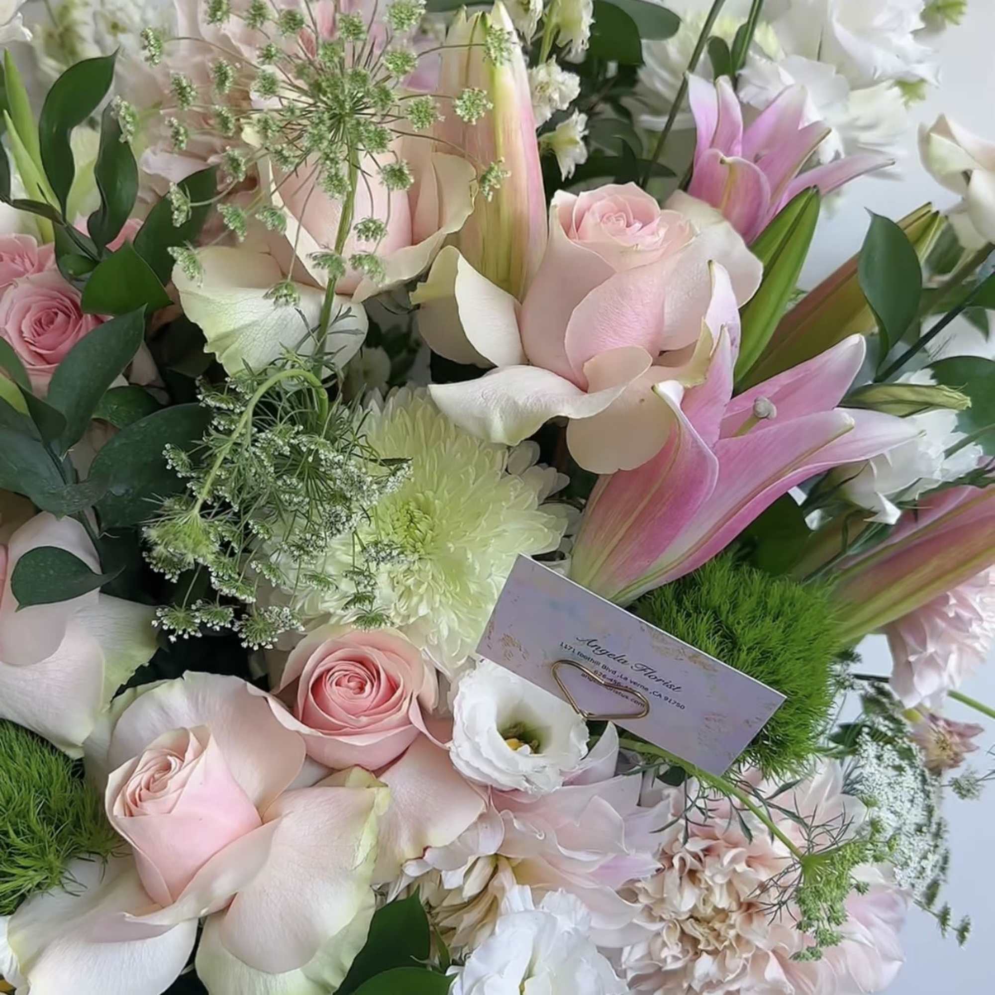 Bouquet of pink and white flowers with greenery in a clear vase
