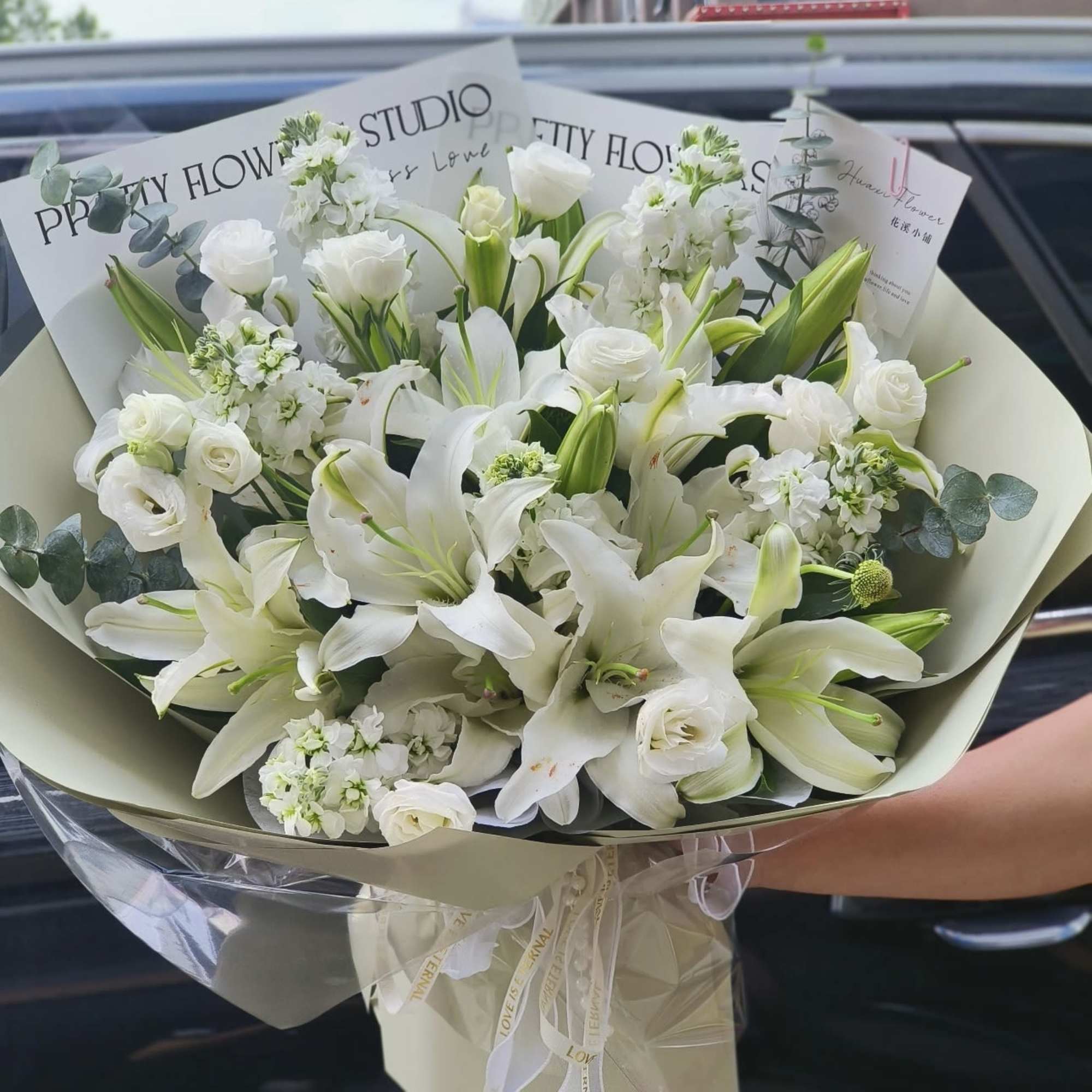 White lily and rose bouquet wrapped in cream paper