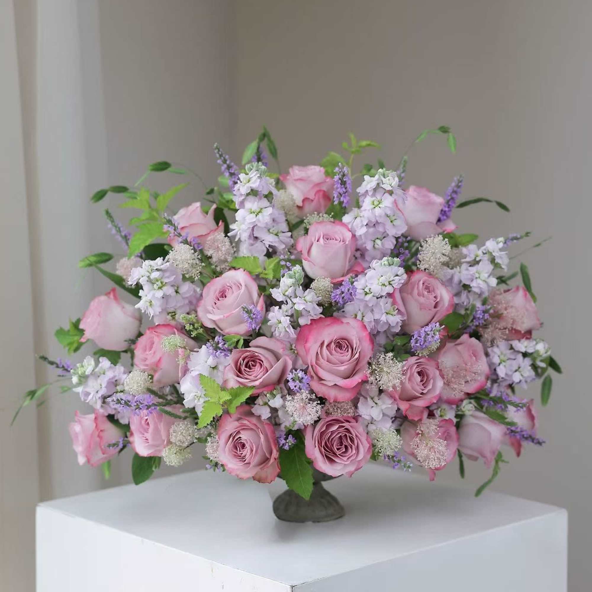 Pink roses and lavender flowers arranged in a low vase