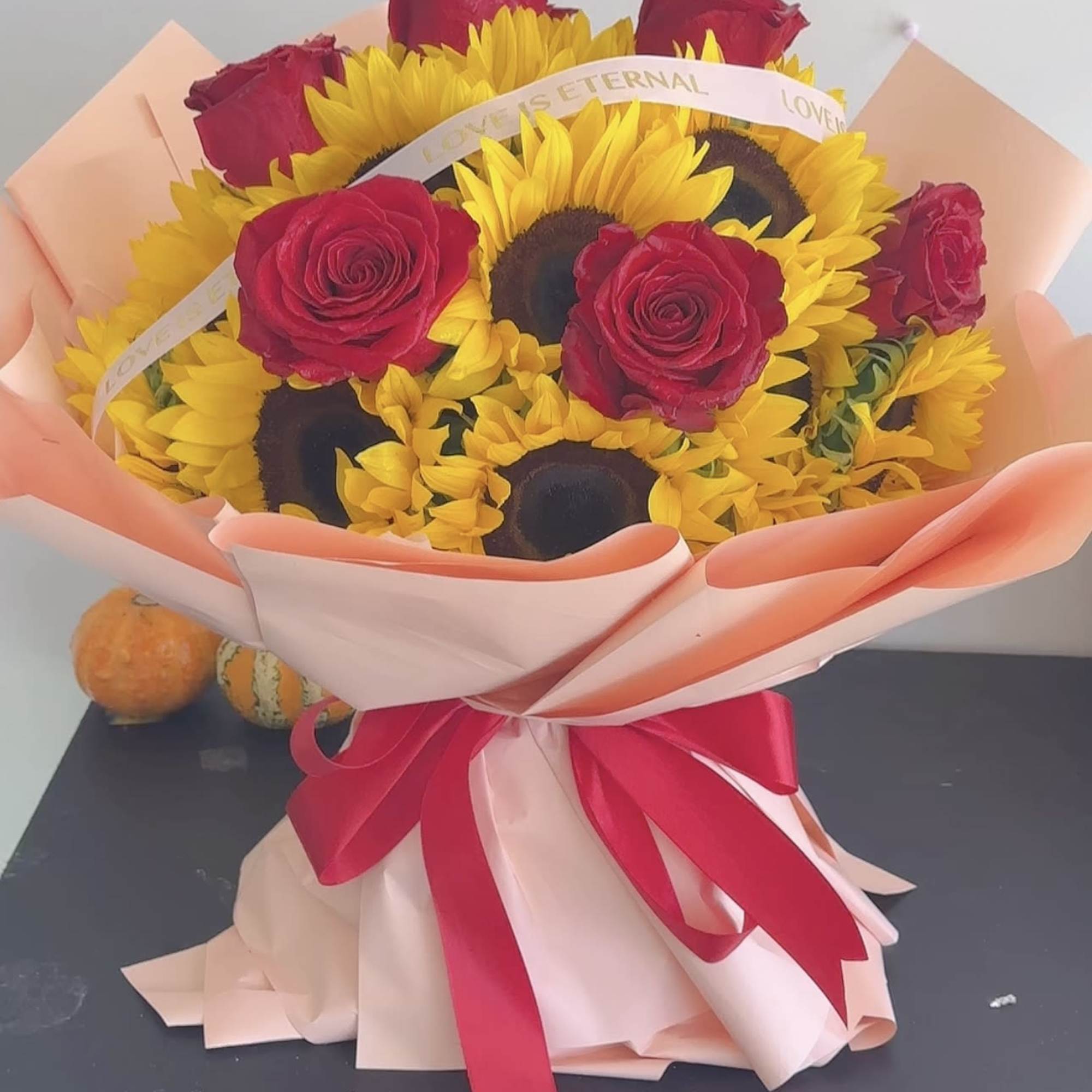 Bouquet of red roses and yellow sunflowers wrapped in pink paper, photo 2 of 4
