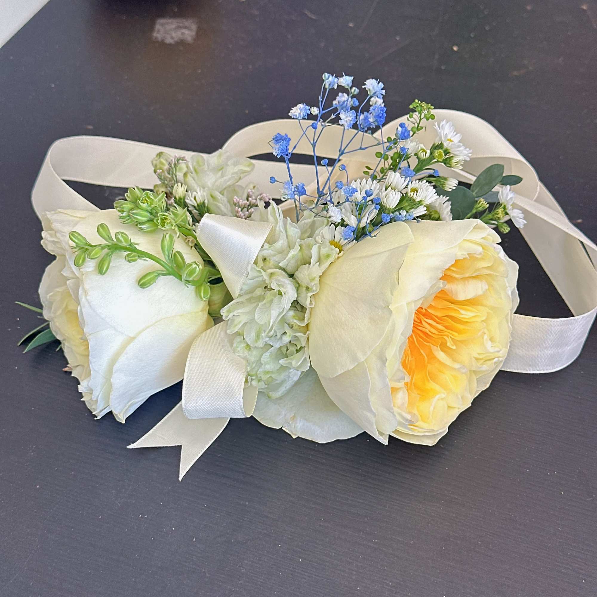 Cream rose bouquet with blue filler flowers and satin ribbon