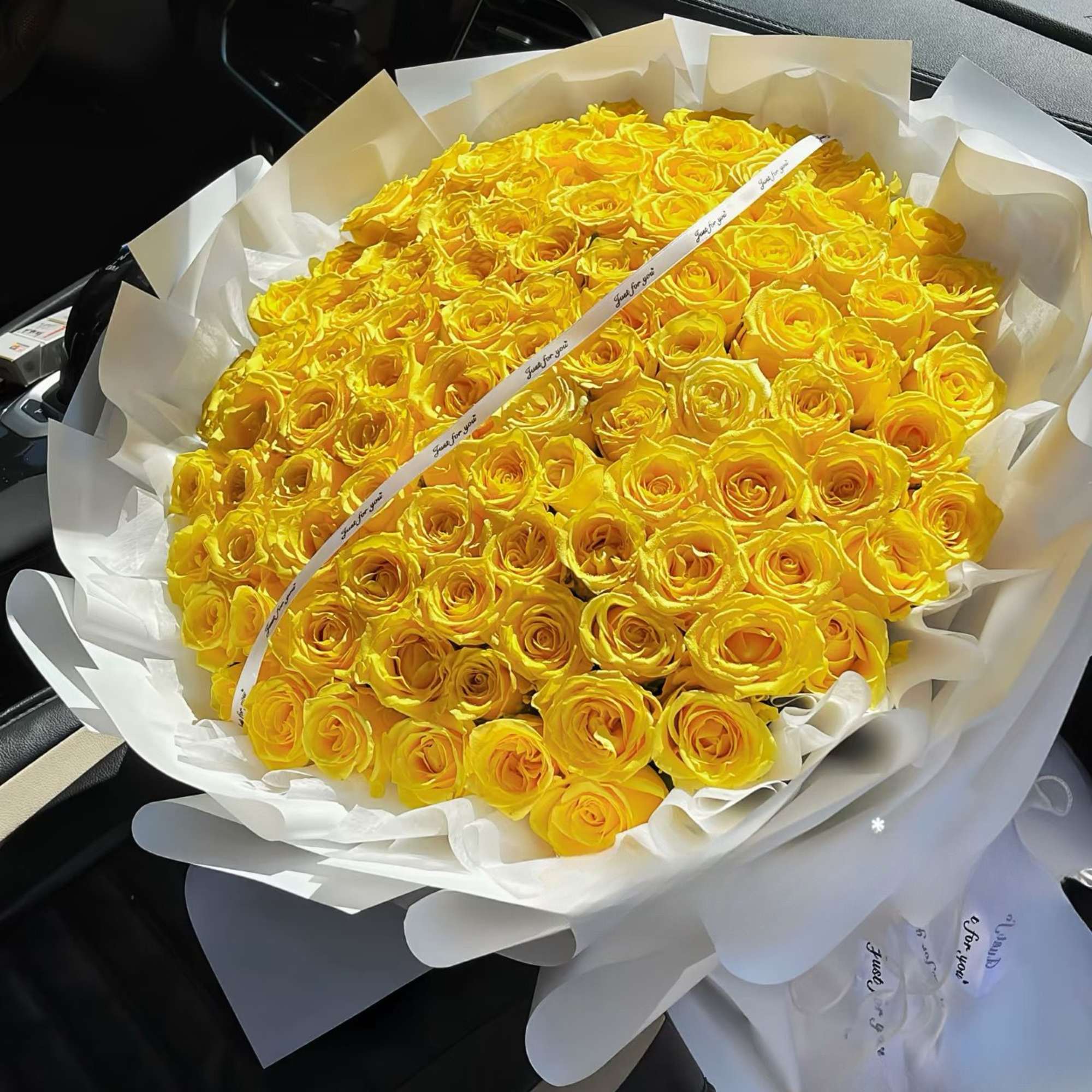 Large bouquet of yellow roses wrapped in white paper, photo 2 of 2