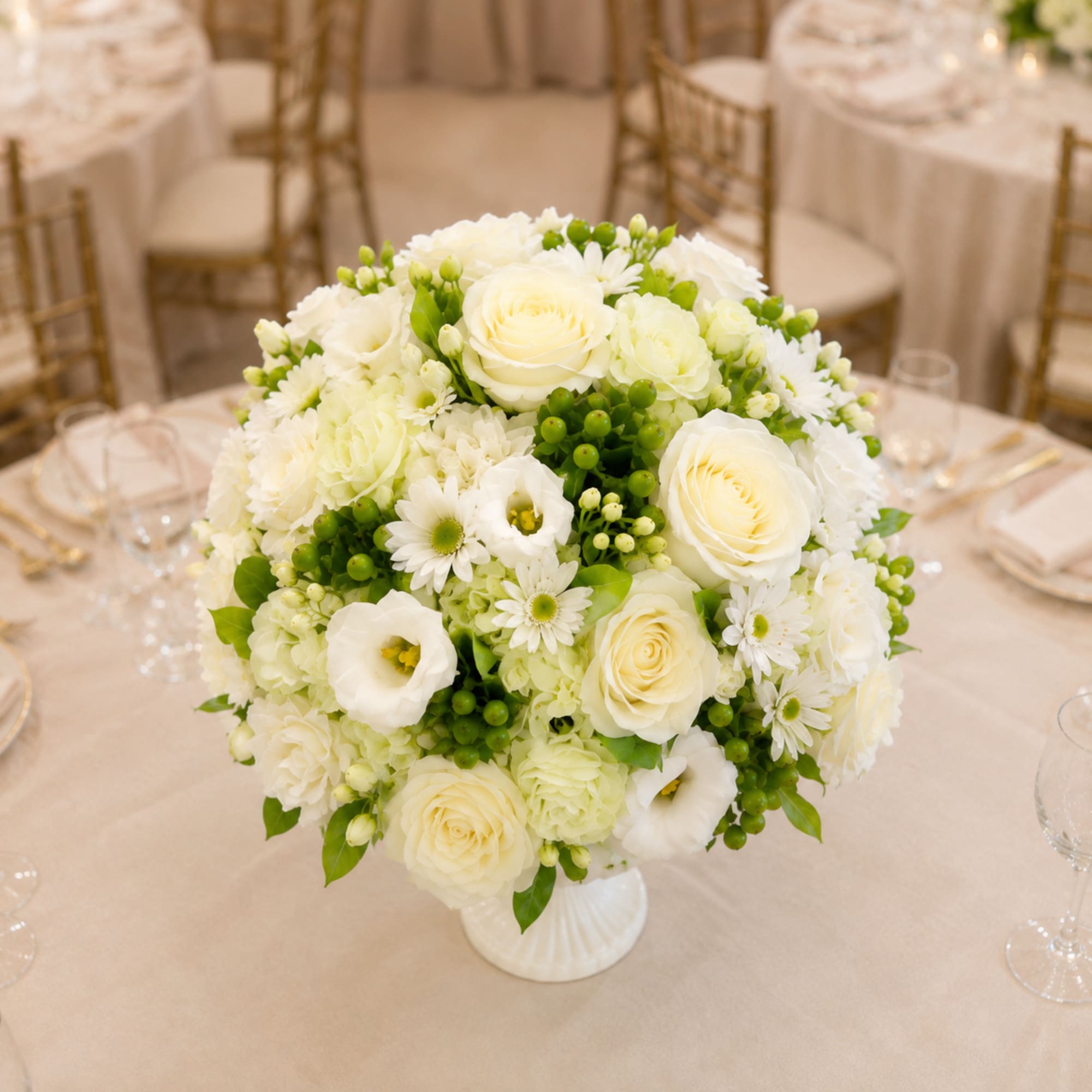 White floral centerpiece in a white vase on a banquet table