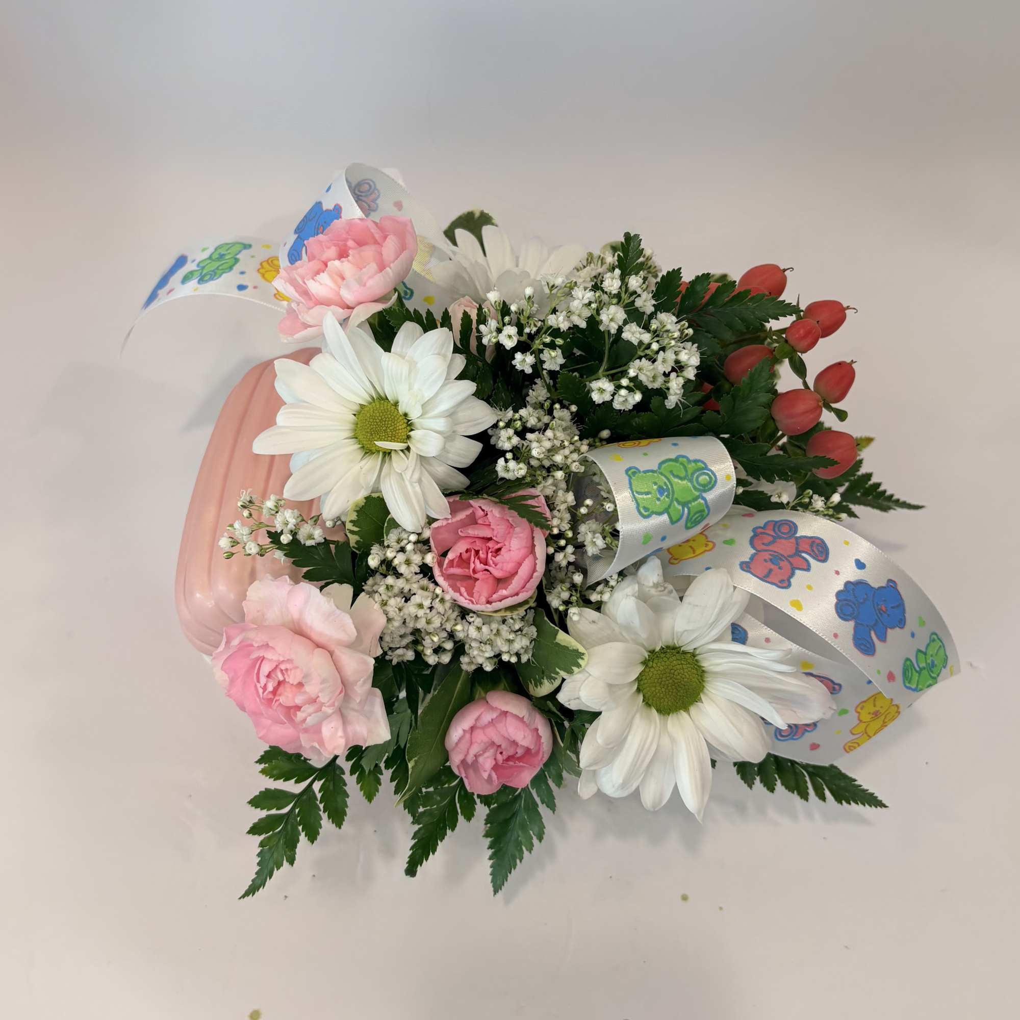 Pink and white flower arrangement with daisies, carnations, and ribbon