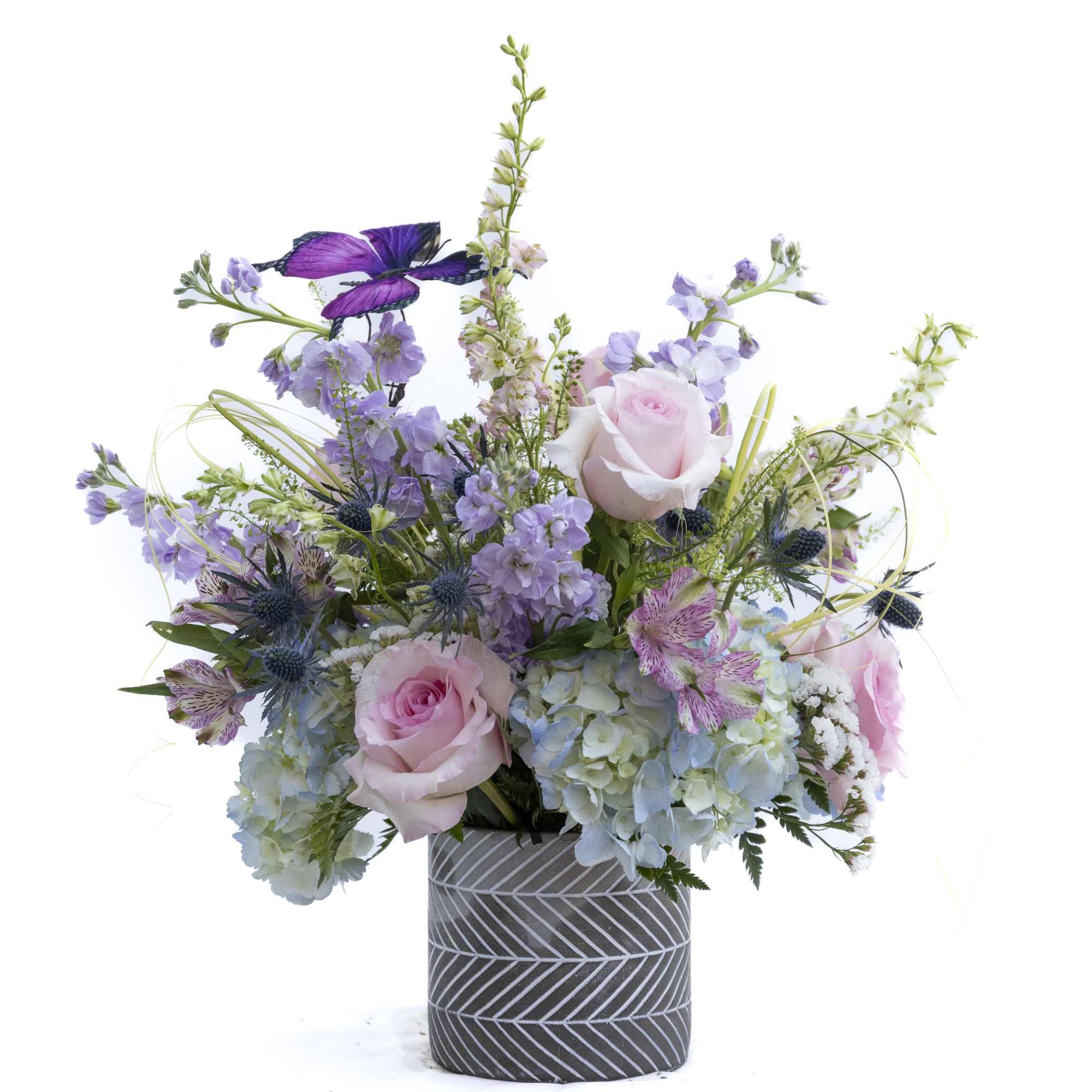 Whimsical and full of garden-inspired charm, this enchanting arrangement brings together soft