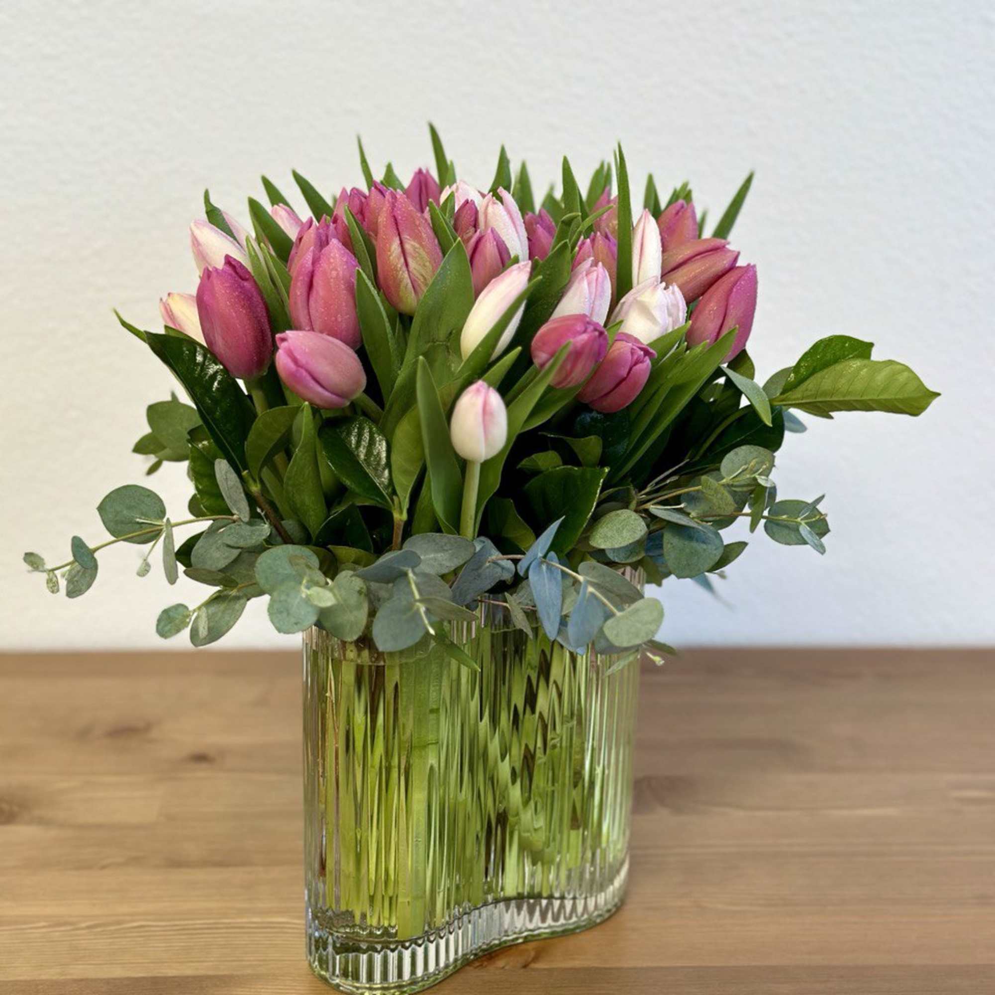 Pink tulips arranged in a clear glass vase