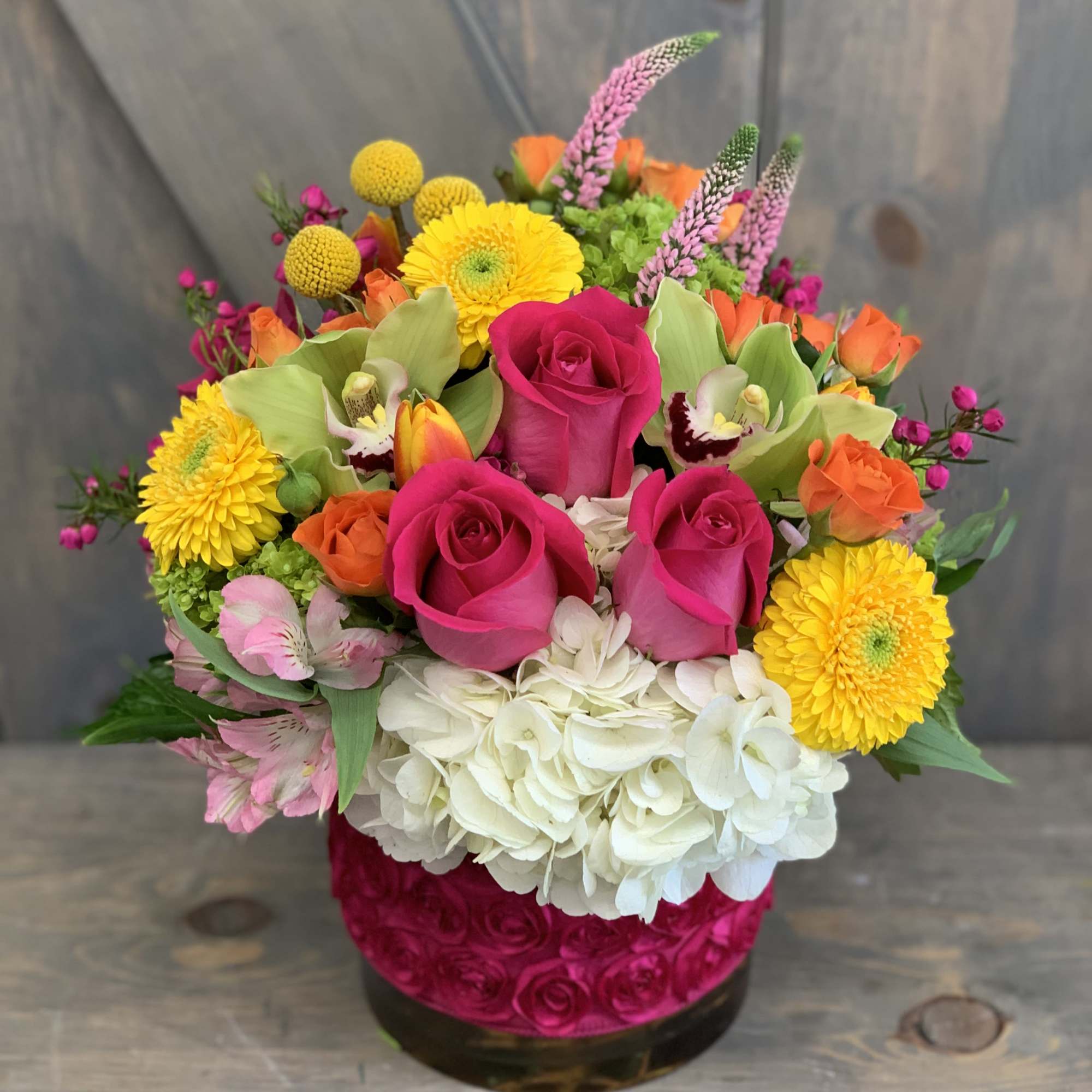 Bright mixed bouquet with pink roses, yellow blooms, and white hydrangea in a vase