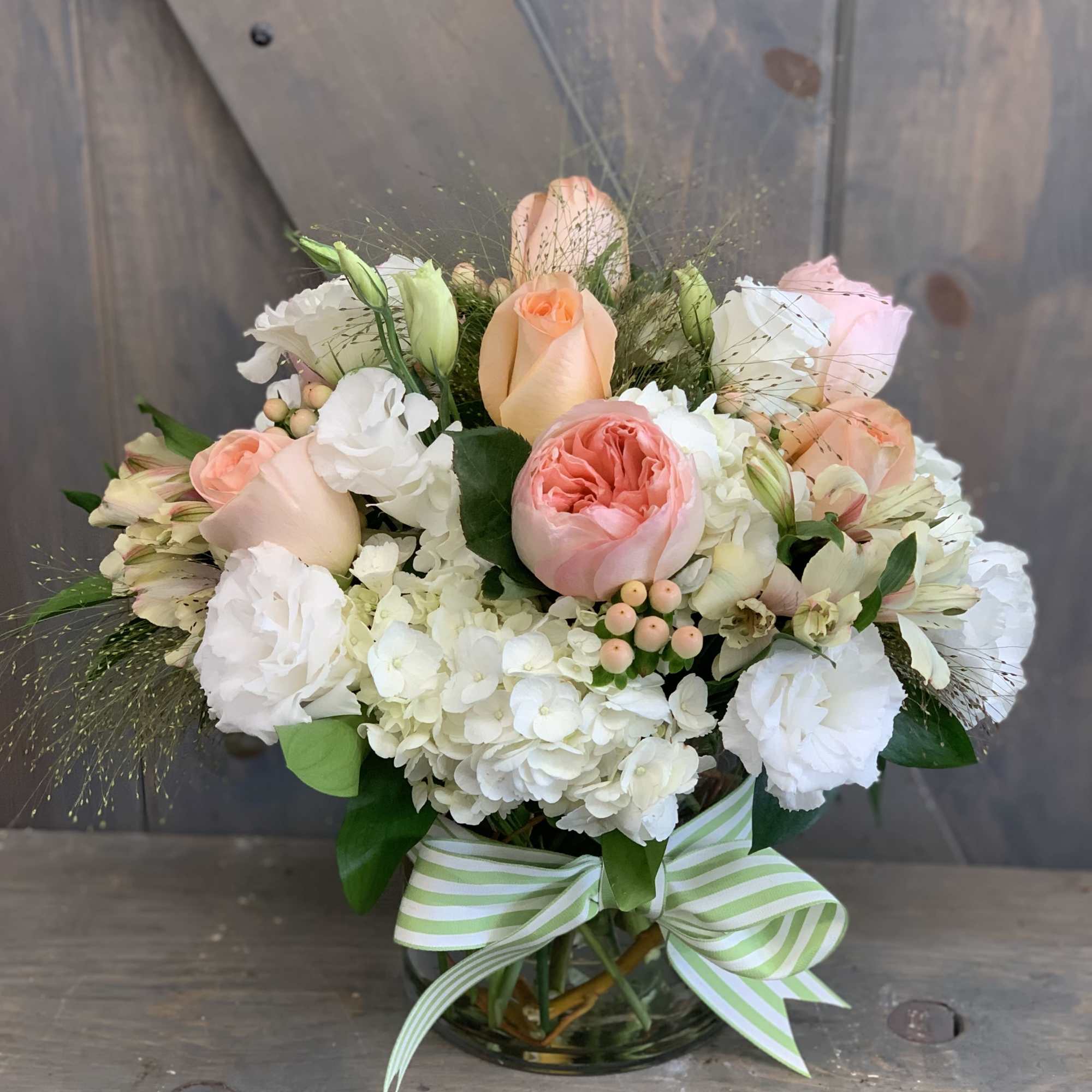 Bouquet of peach and white roses with hydrangeas in a glass vase