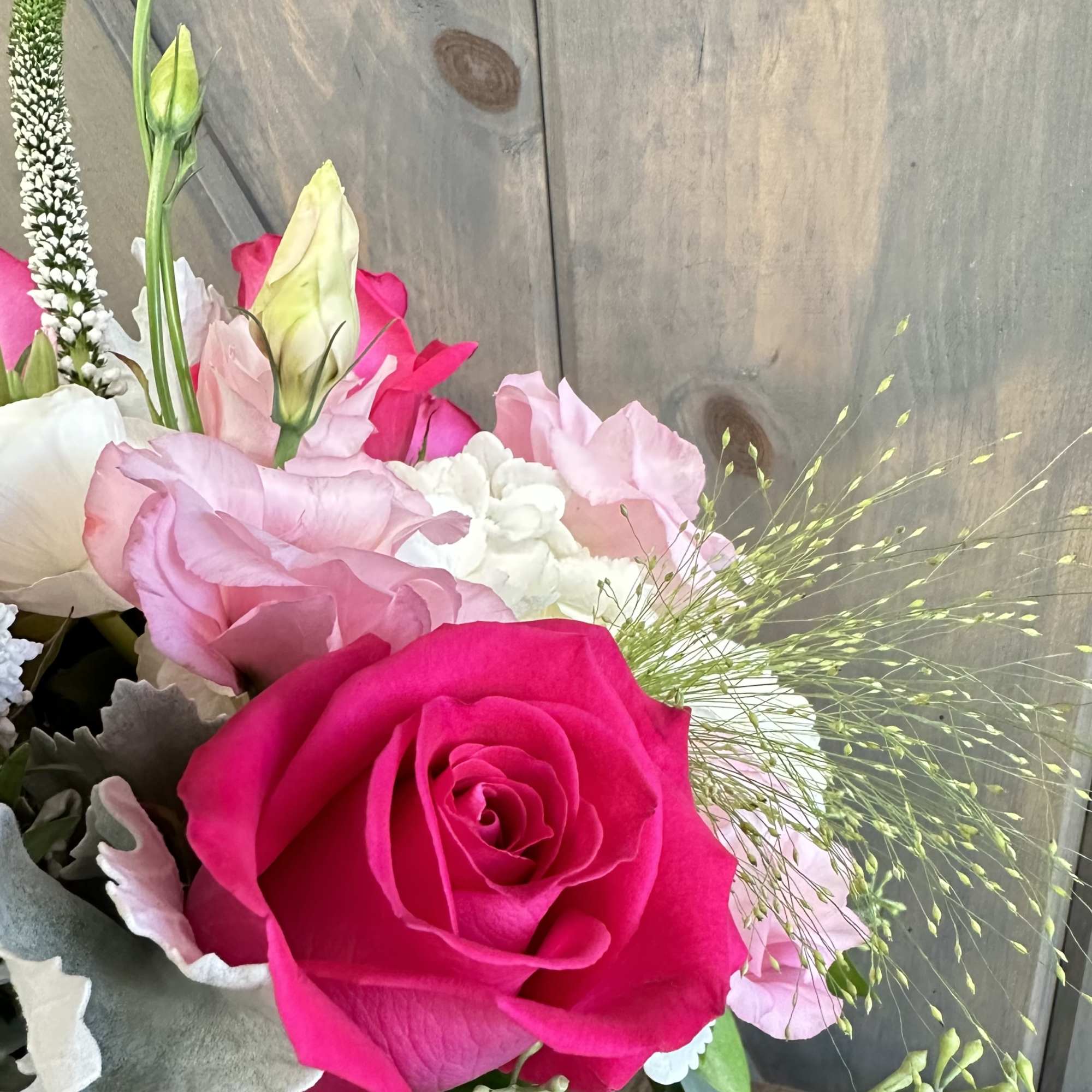 Bouquet with a bright pink rose and pale pink blooms