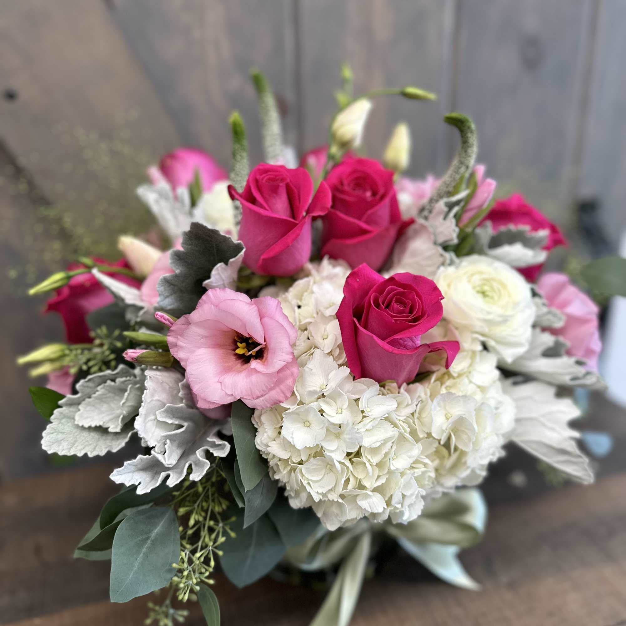 Pink roses and white blooms arranged in a low bouquet
