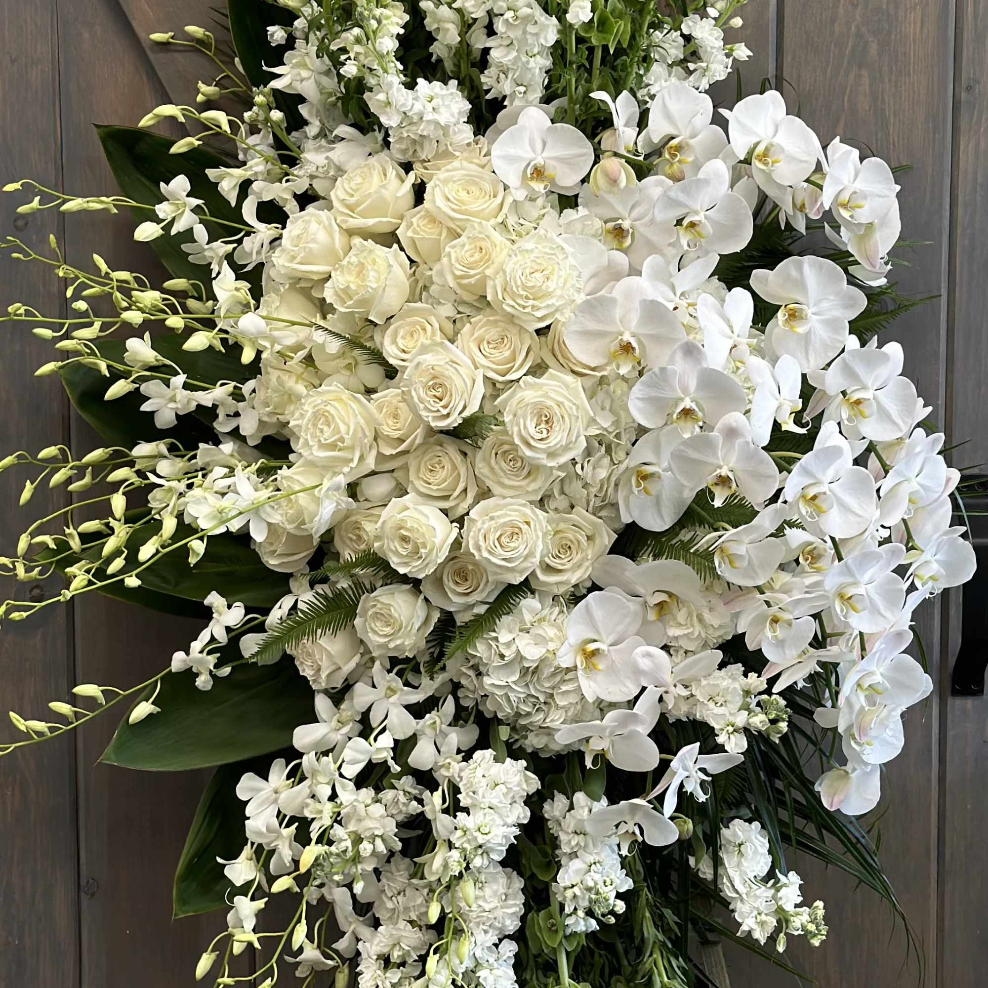 Tall white floral standing spray with roses and orchids
