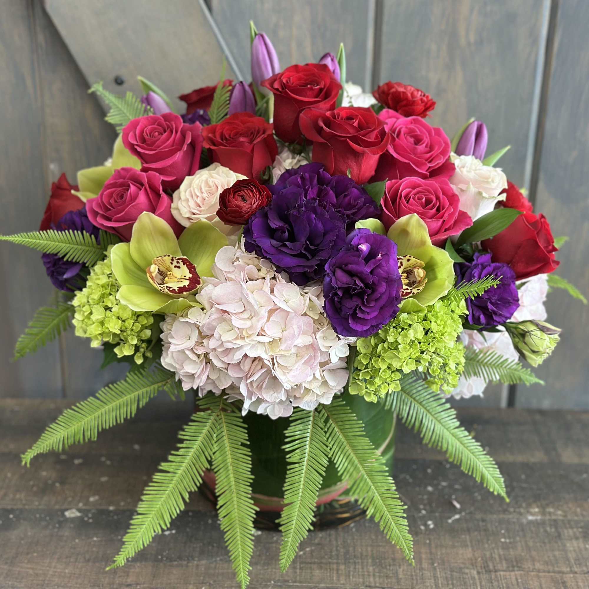 Mixed bouquet of red, pink, purple, and white flowers in a vase