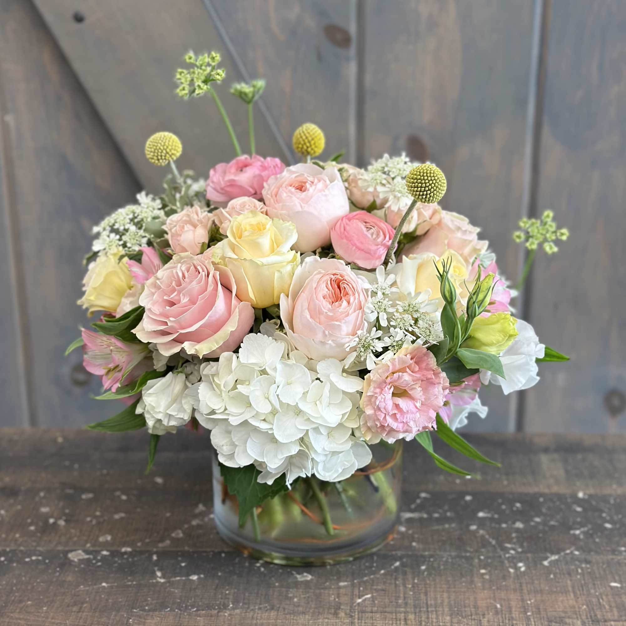 Pastel bouquet of roses and hydrangeas in a glass vase