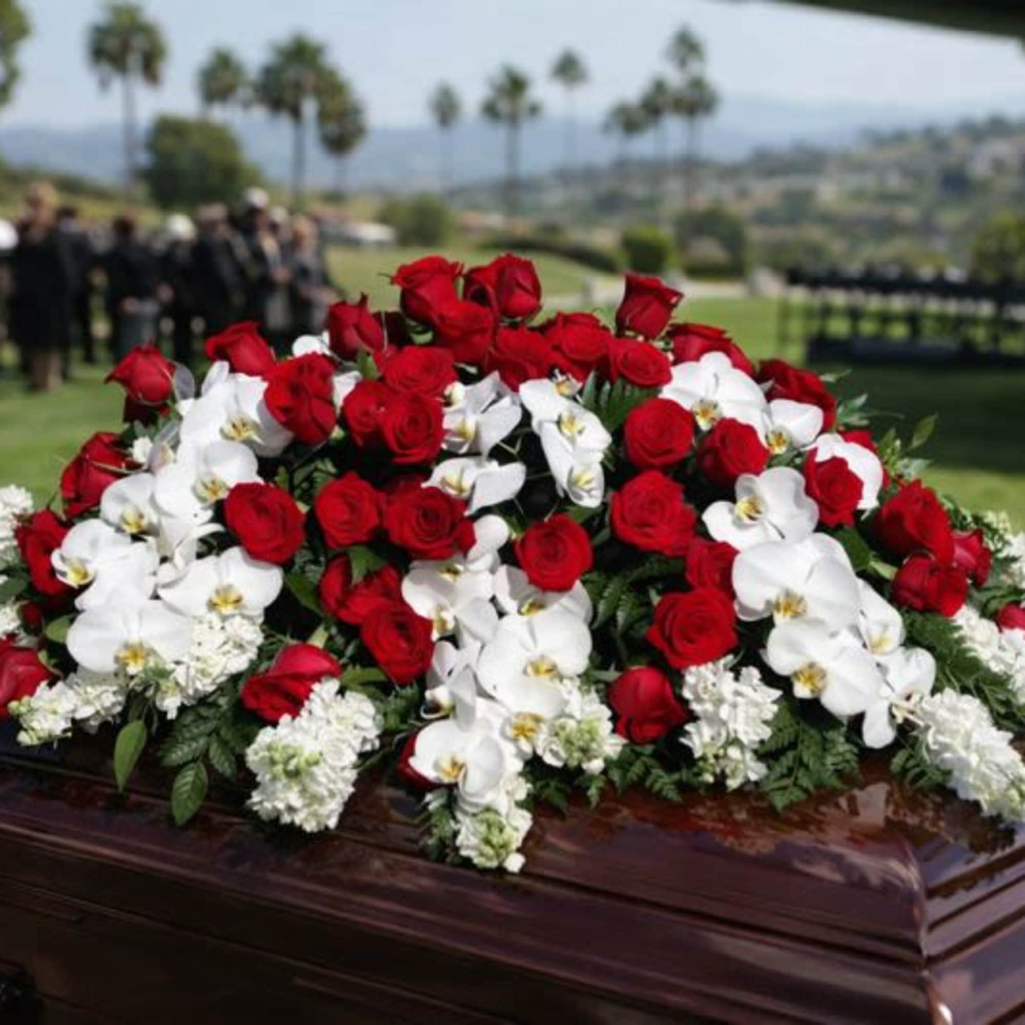 Red roses and white orchids arranged on a casket