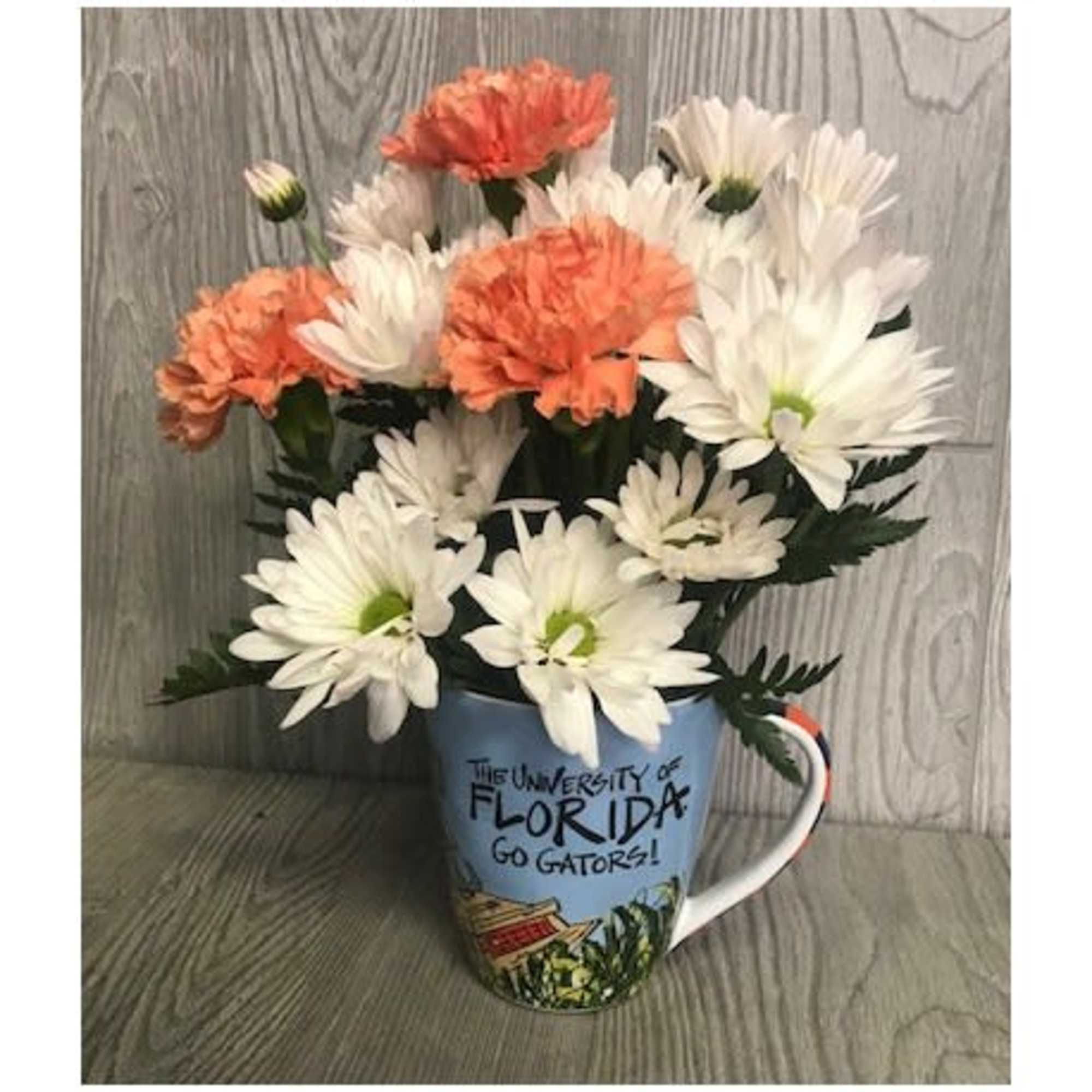 White and peach daisies arranged in a Florida mug