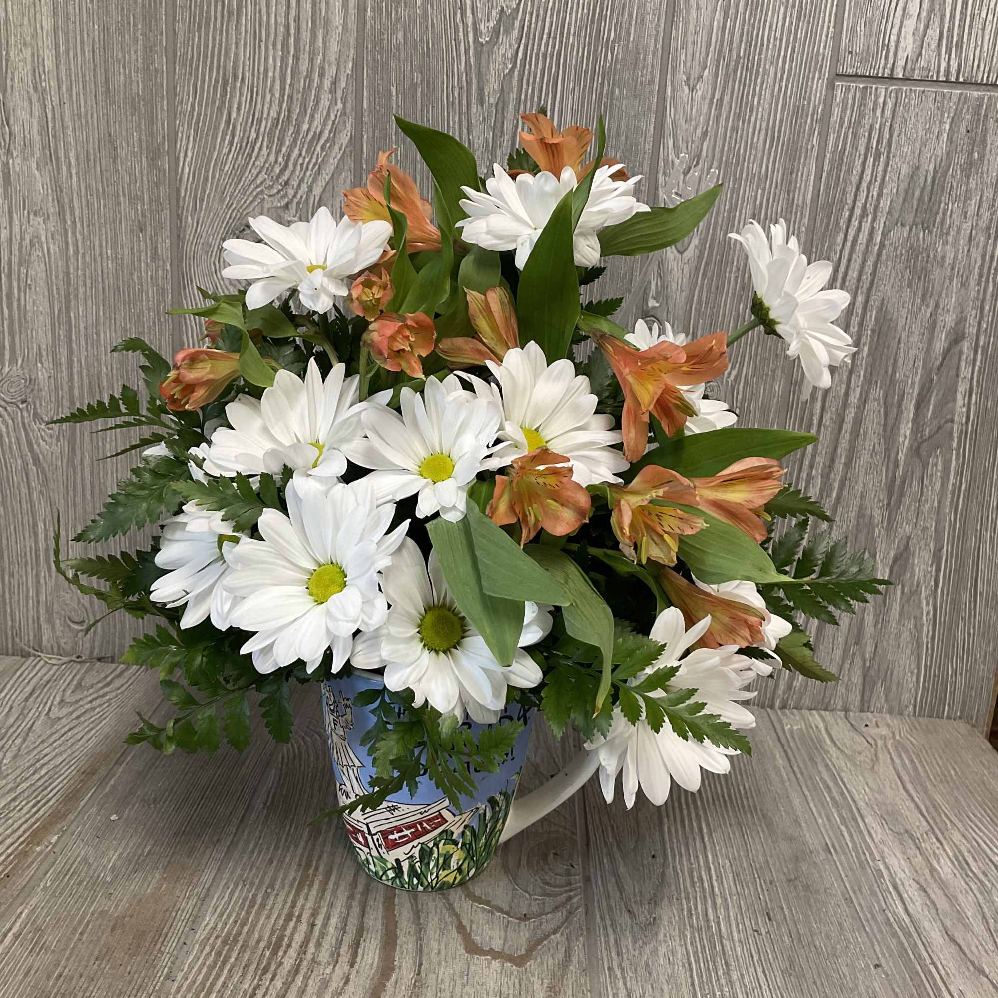 An arrangement of fresh daisies in a keepsake ceramic Gators mug! Flowers