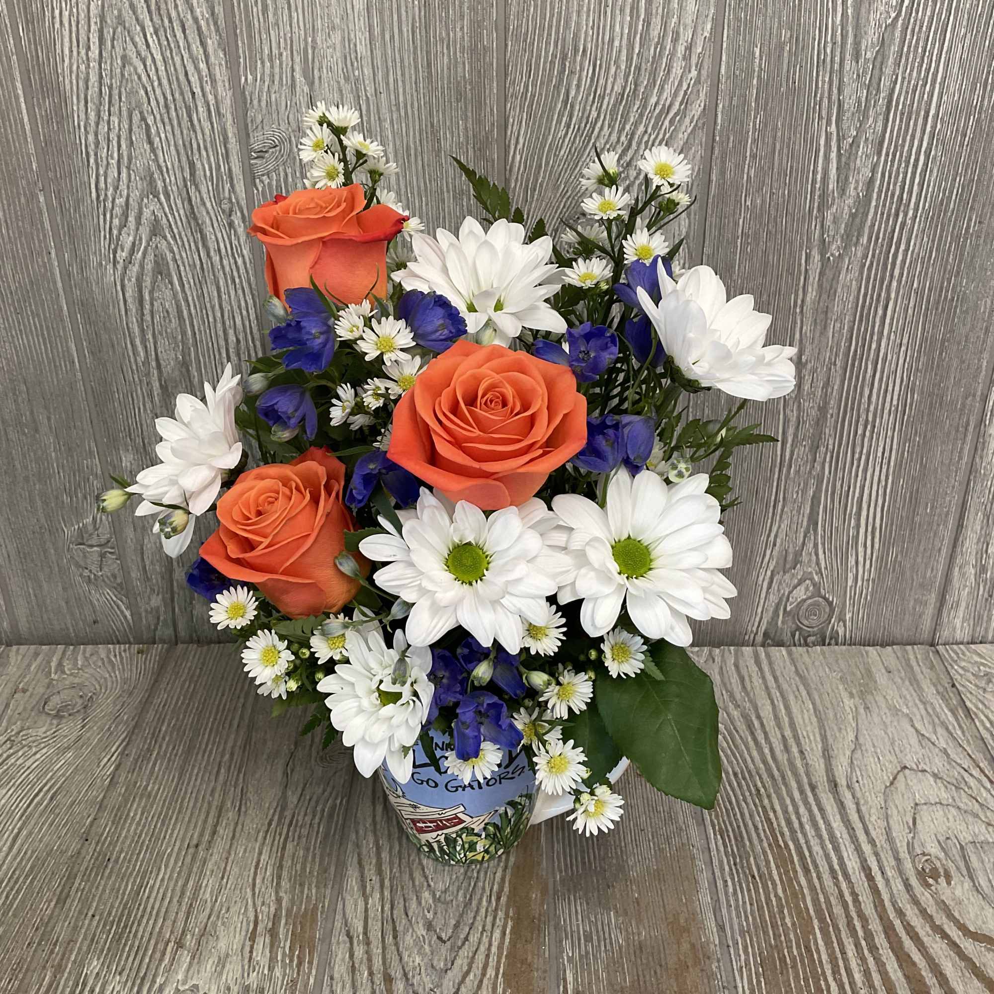 Mixed flowers in a keepsake ceramic Gator artwork mug. Flowers may vary.