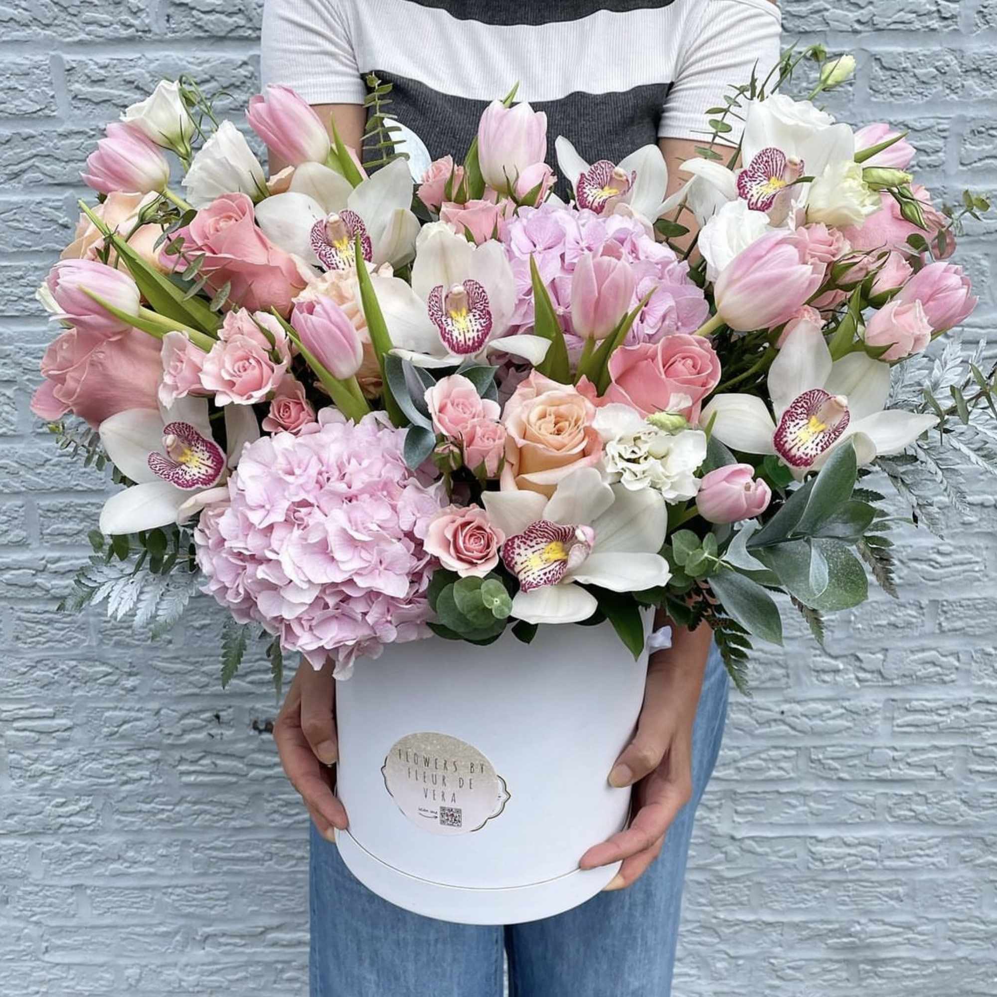 Large pink and white flower arrangement in a white hat box