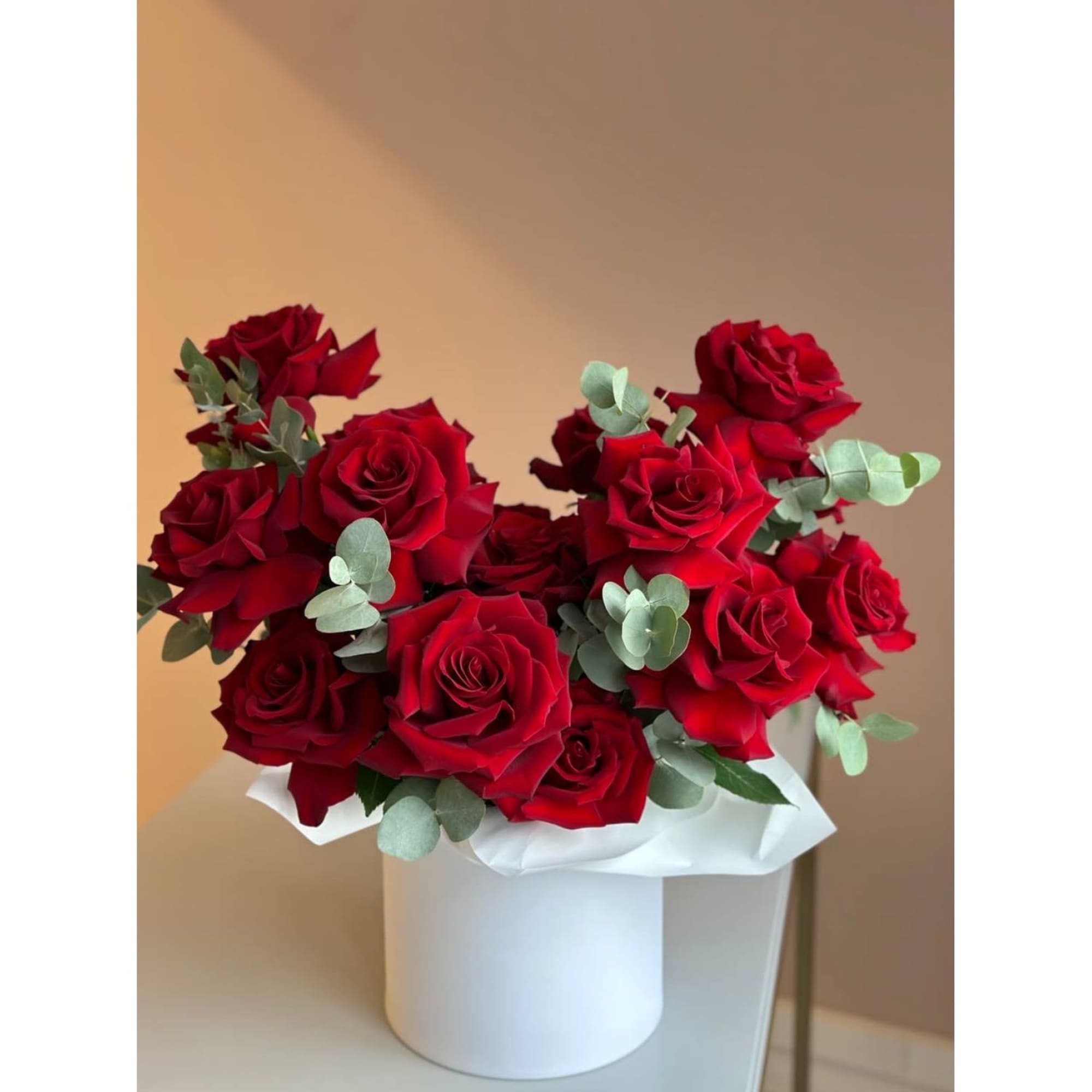 Bouquet of red roses with eucalyptus in a white box