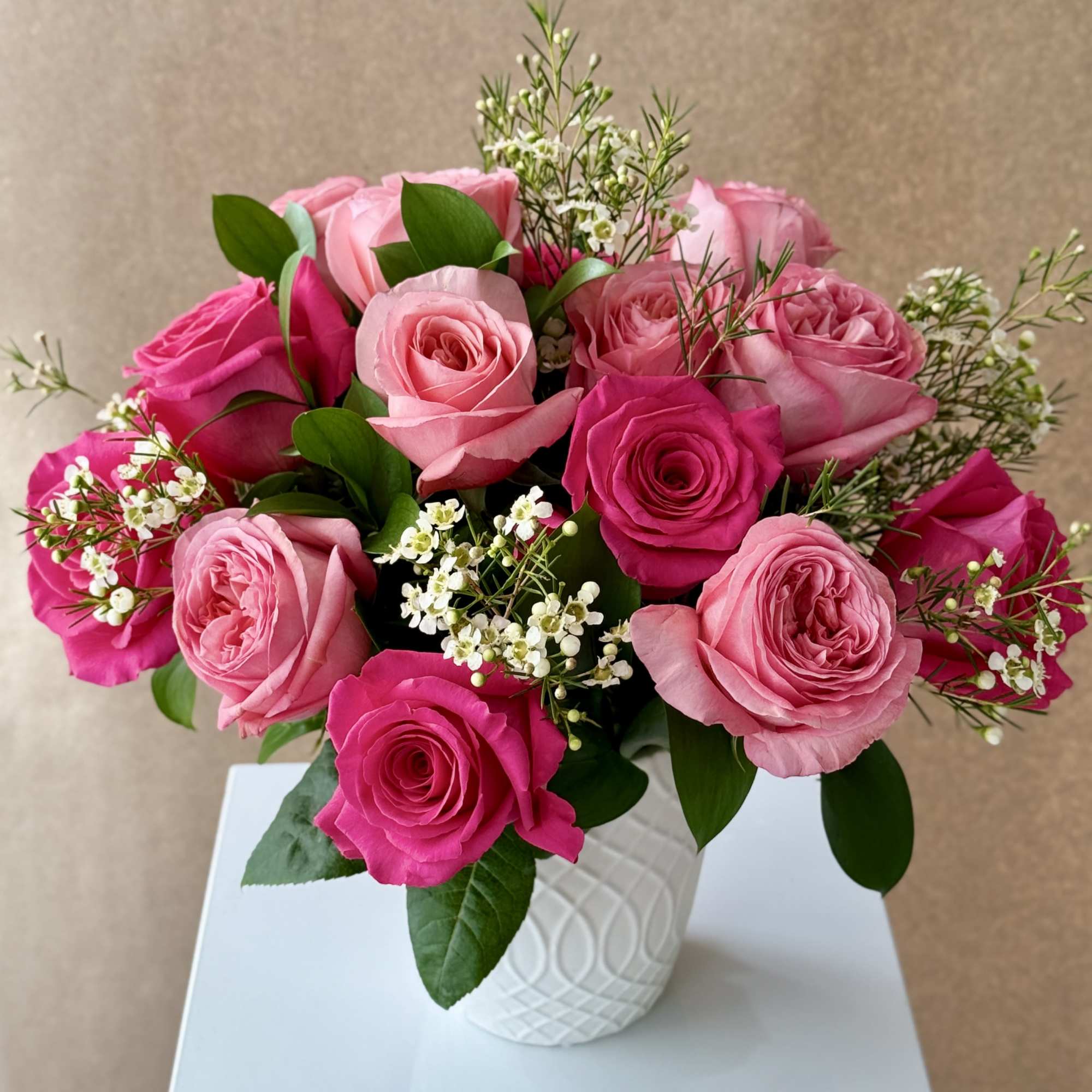 Pink roses arranged in a white textured vase