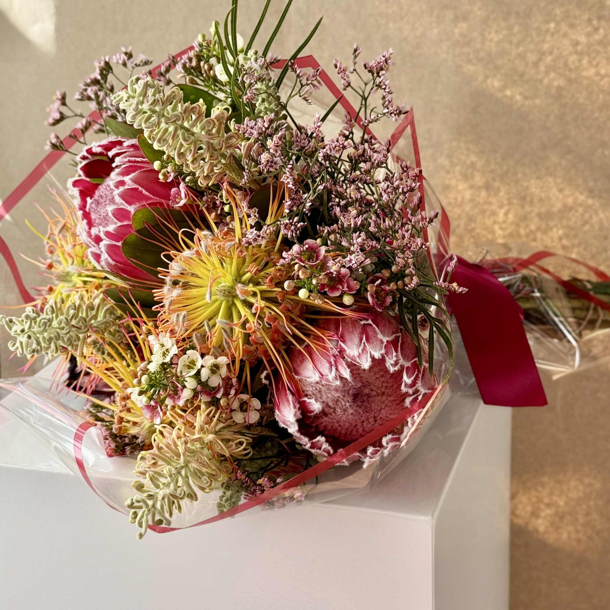 Exotic bouquet with protea and grevillea with seasonal accents.