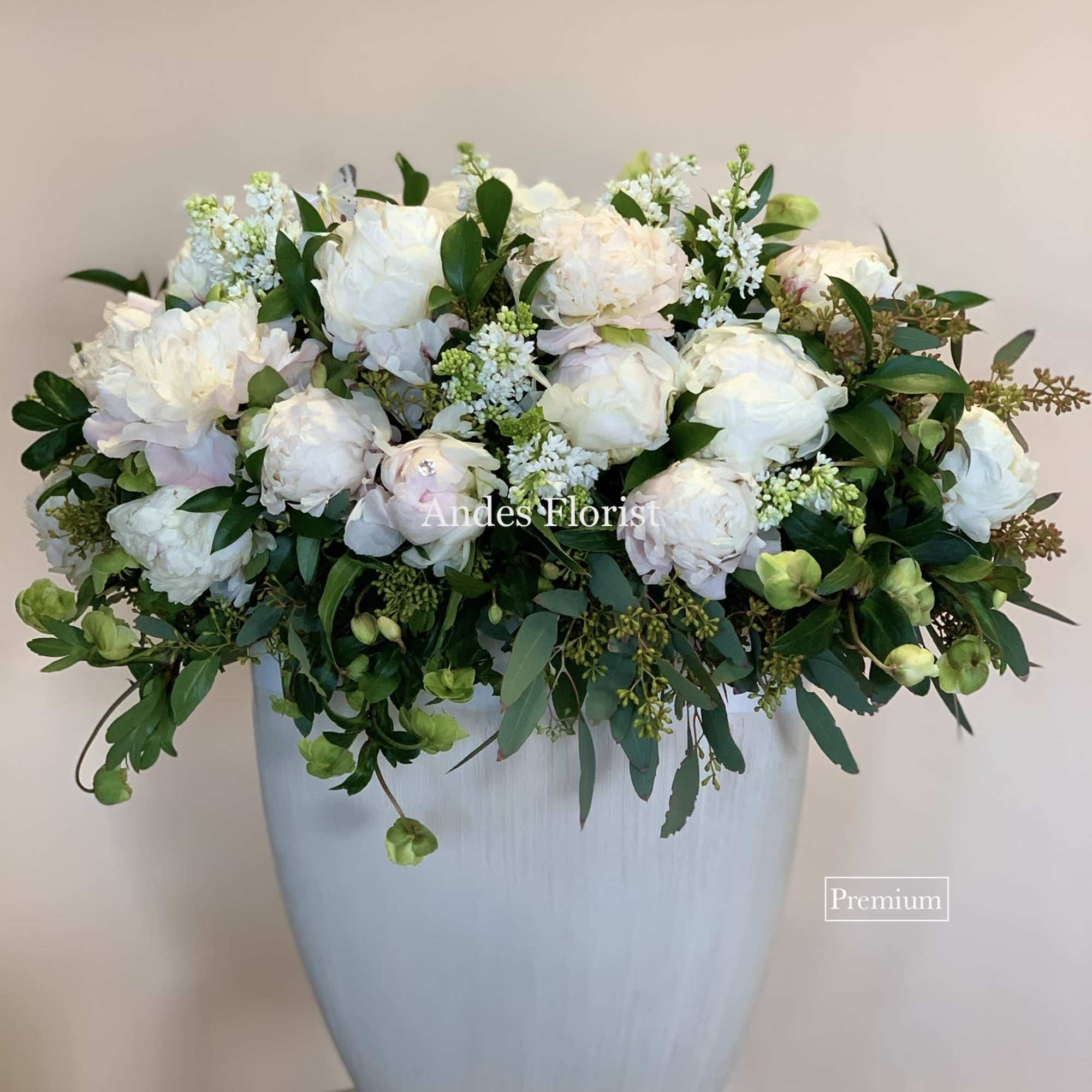 White floral arrangement in a tall pale vase