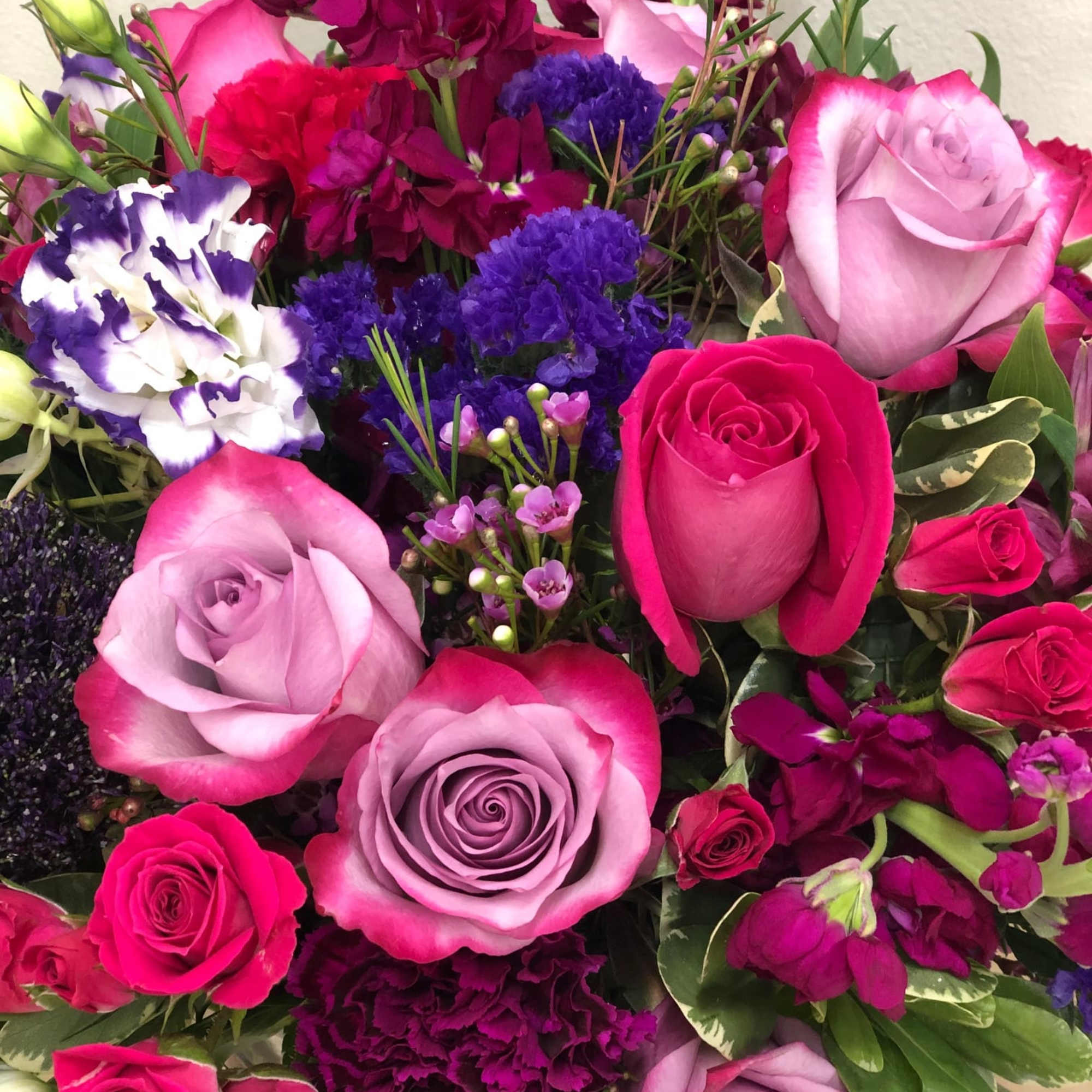 Bouquet of pink and lavender roses with purple filler flowers