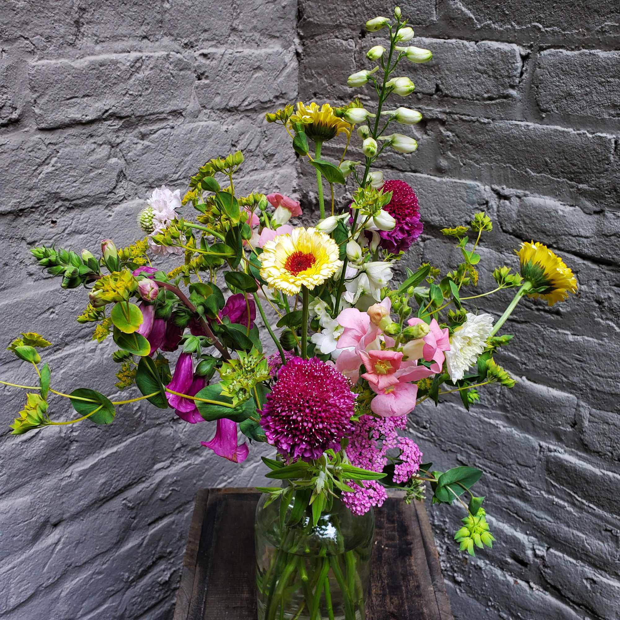 Mixed bouquet in a glass vase with pink, white, and yellow flowers