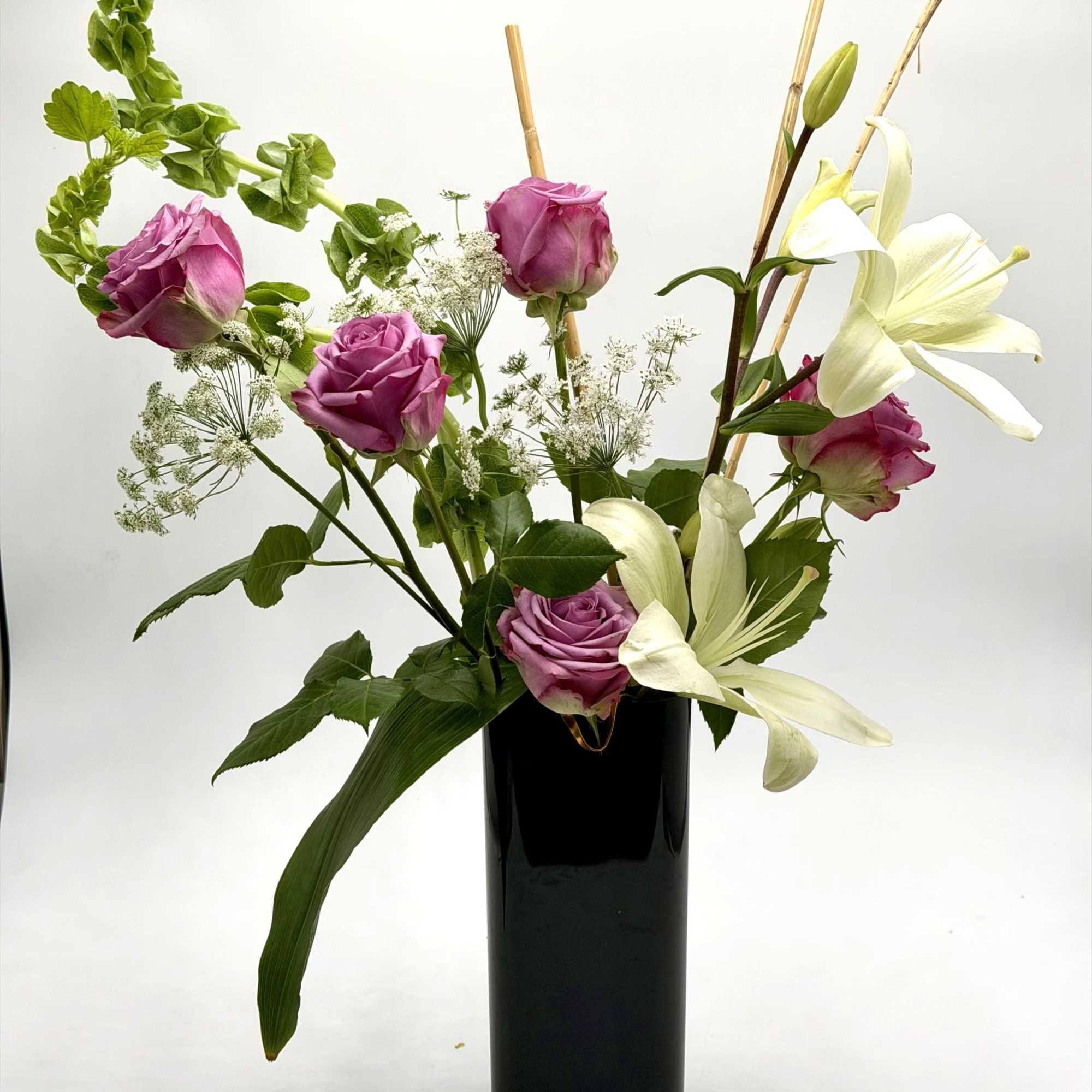 A graceful blend of lavender roses and elegant white lilies creates a