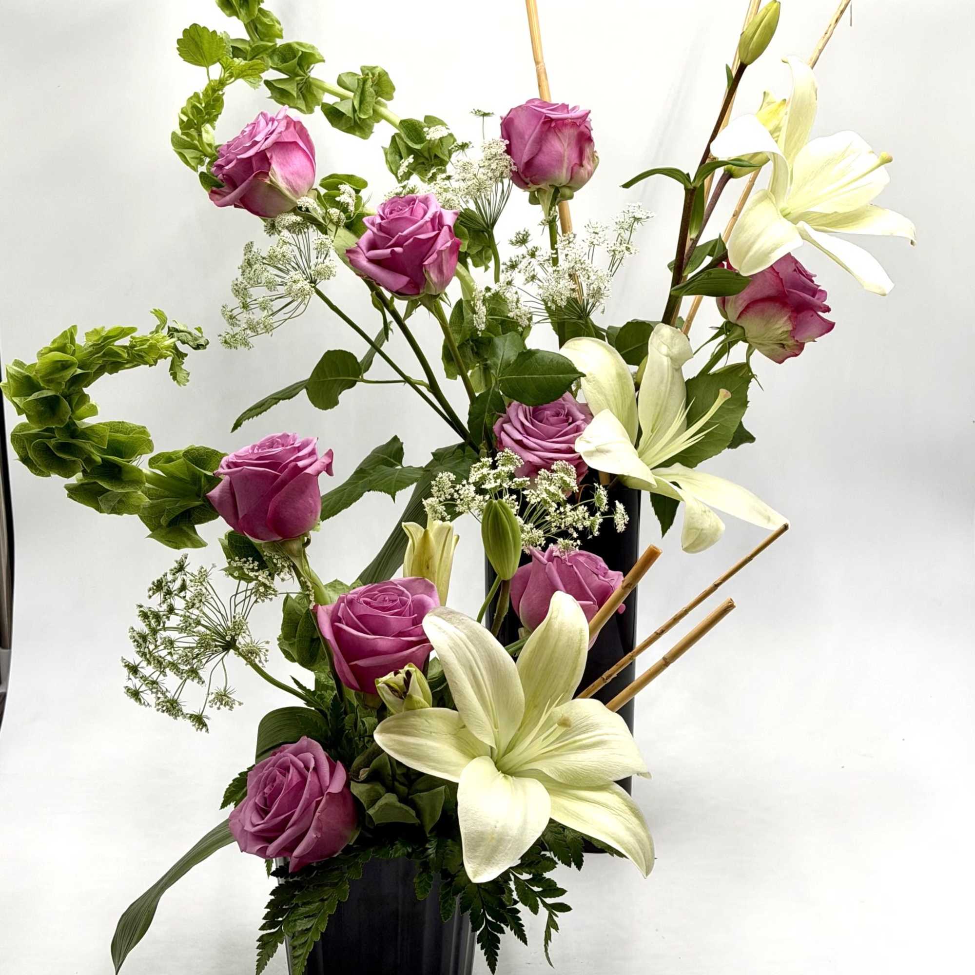 A graceful blend of lavender roses and elegant white lilies creates a