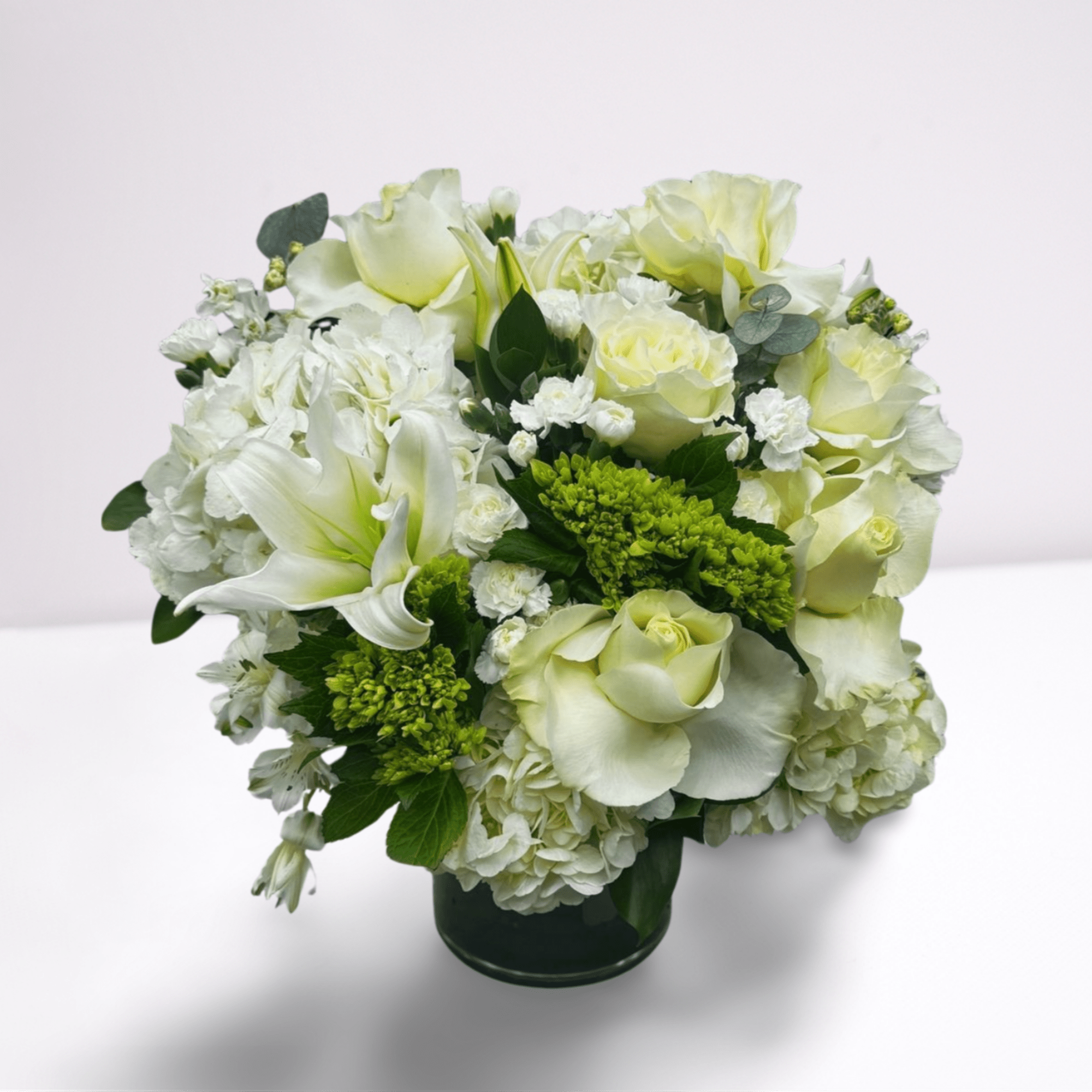 A soft, timeless mix of white roses, lilies, hydrangea, and lush greenery, photo 2 of 2