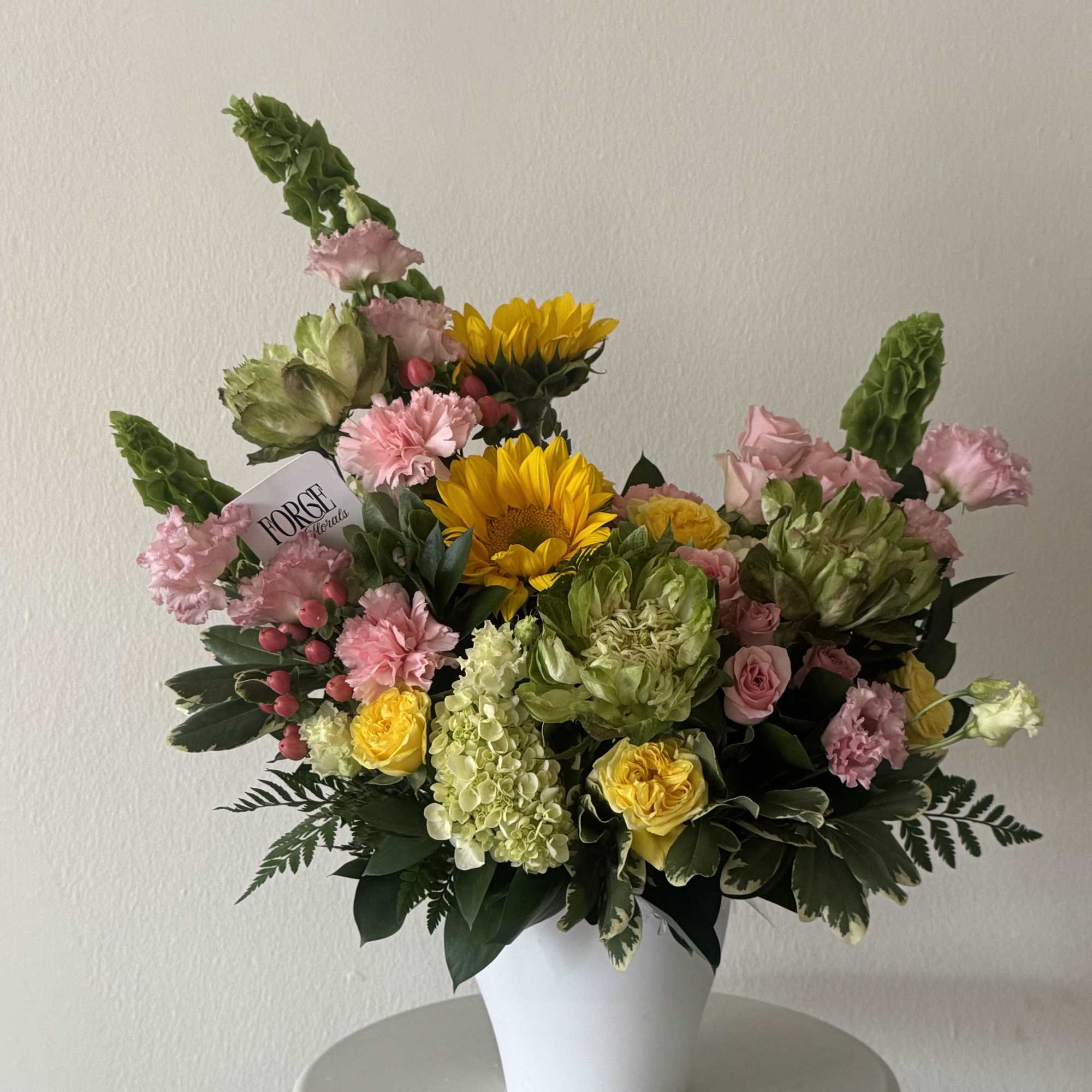  cheerful garden-style arrangement featuring premium seasonal blooms in soft pink, fresh