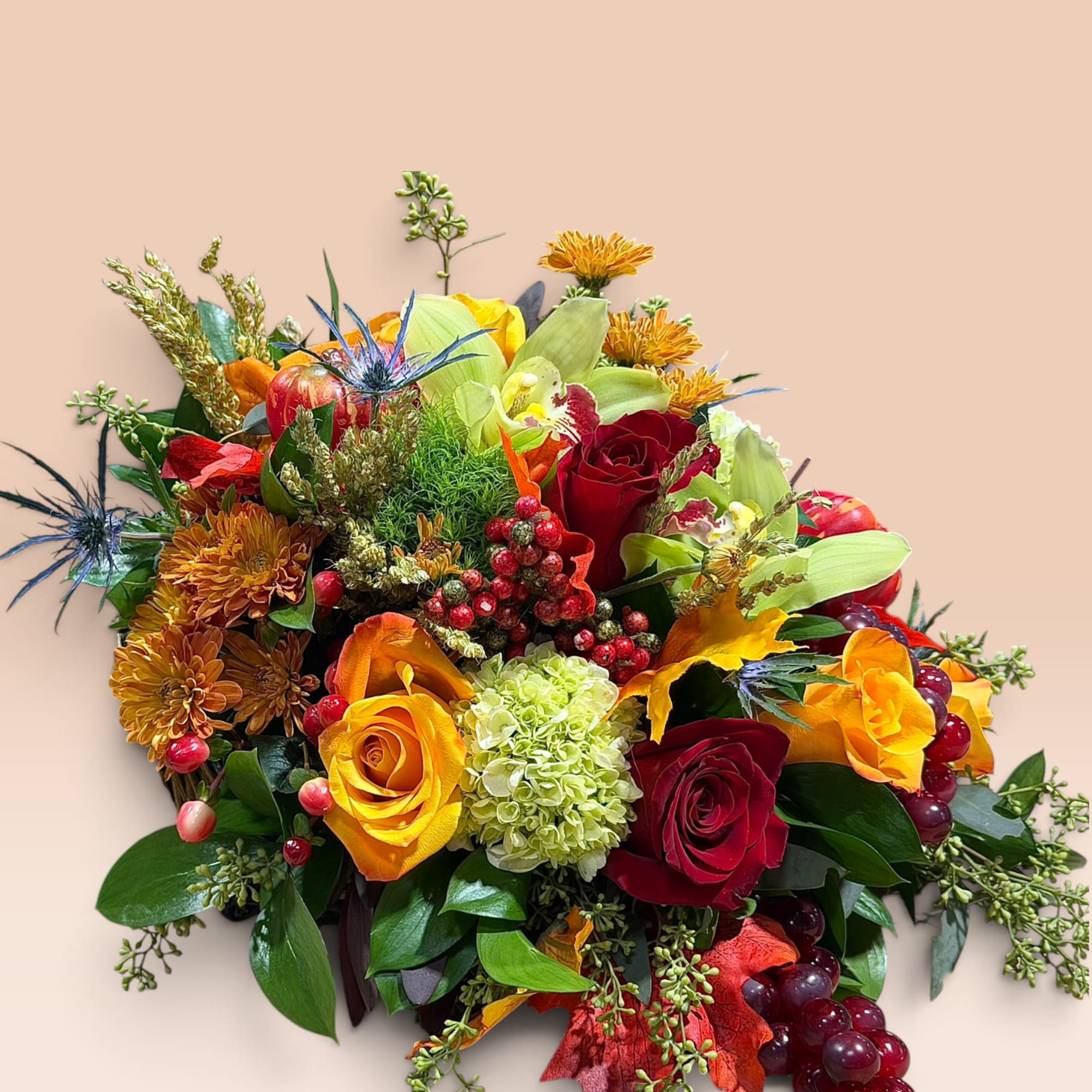 Mixed bouquet with red and yellow roses, orchids, and berries