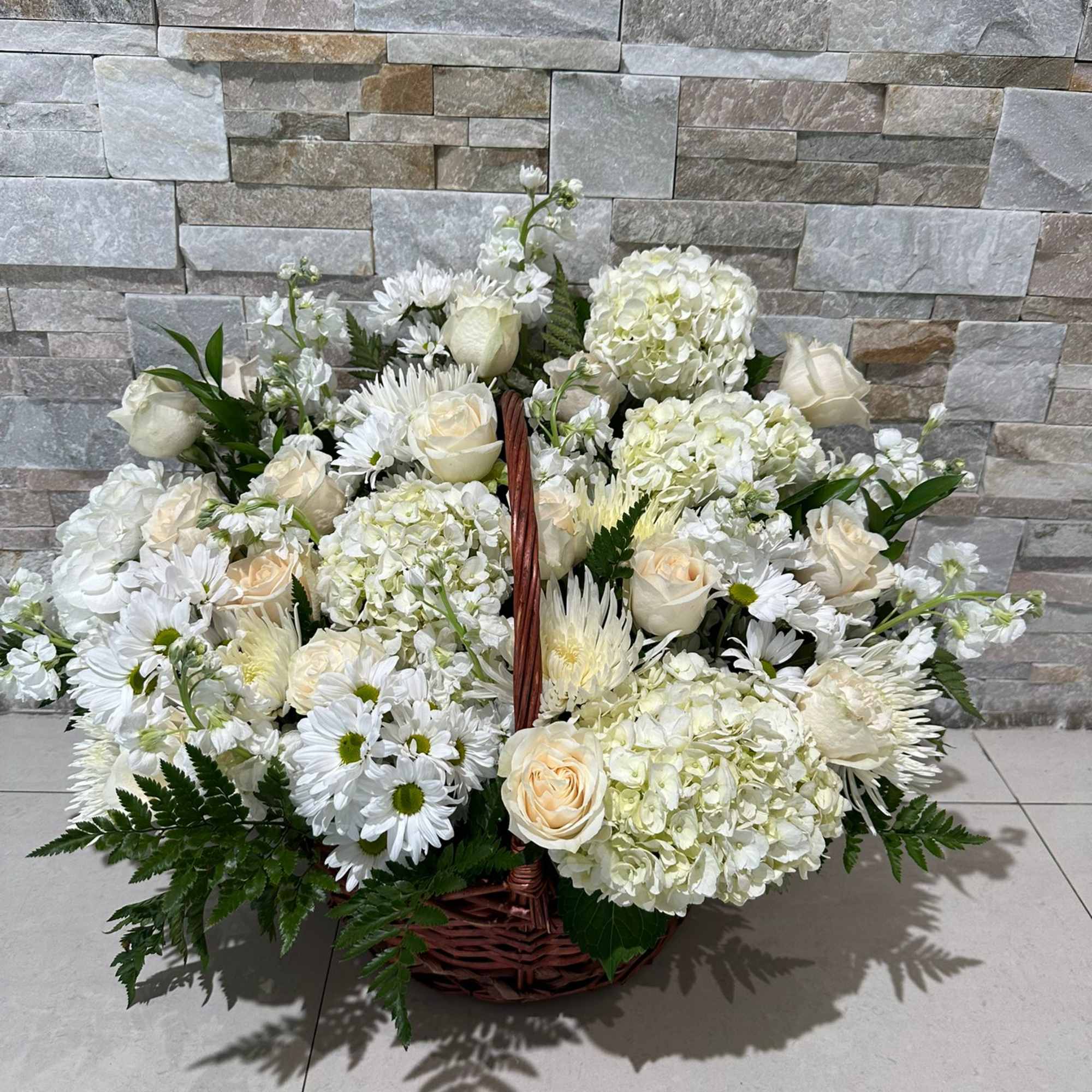 WHITE BASKET WITH ROSES, HYDRANGEAS AND A NICE MIX OF WHITES WITH