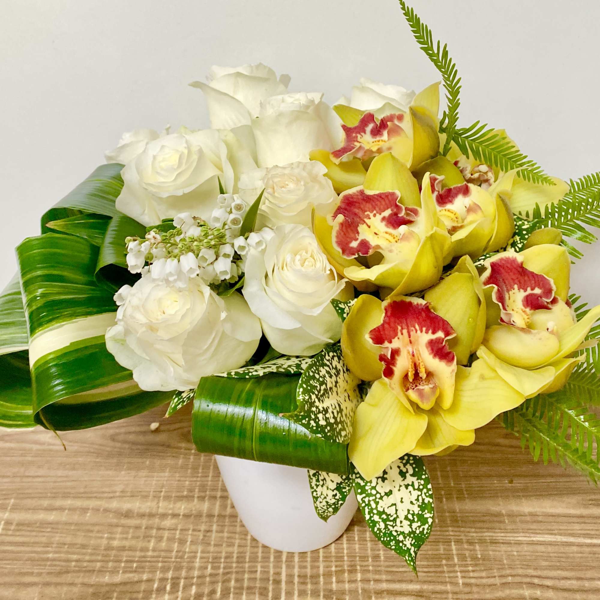 in a white vase combinations of white hydrangeas, green moms, pink cymbidium