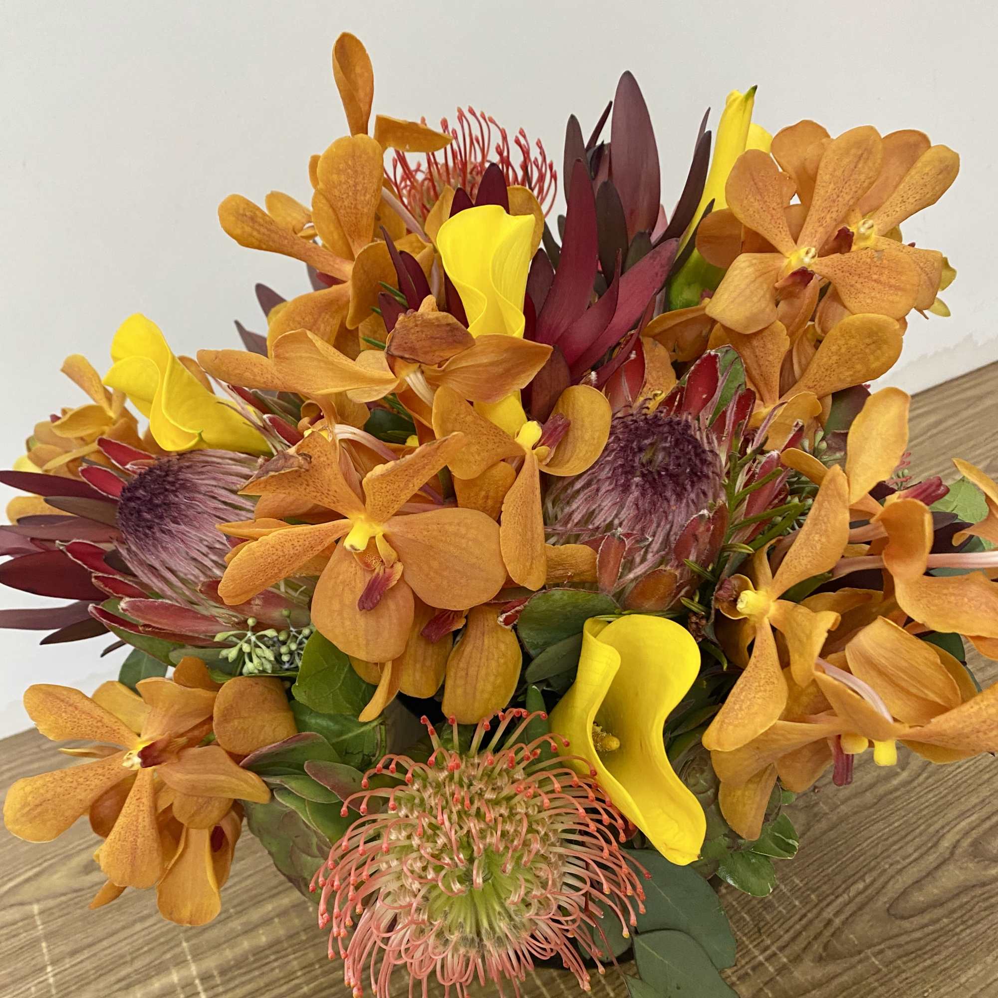 Orange and yellow tropical bouquet with protea and calla lilies