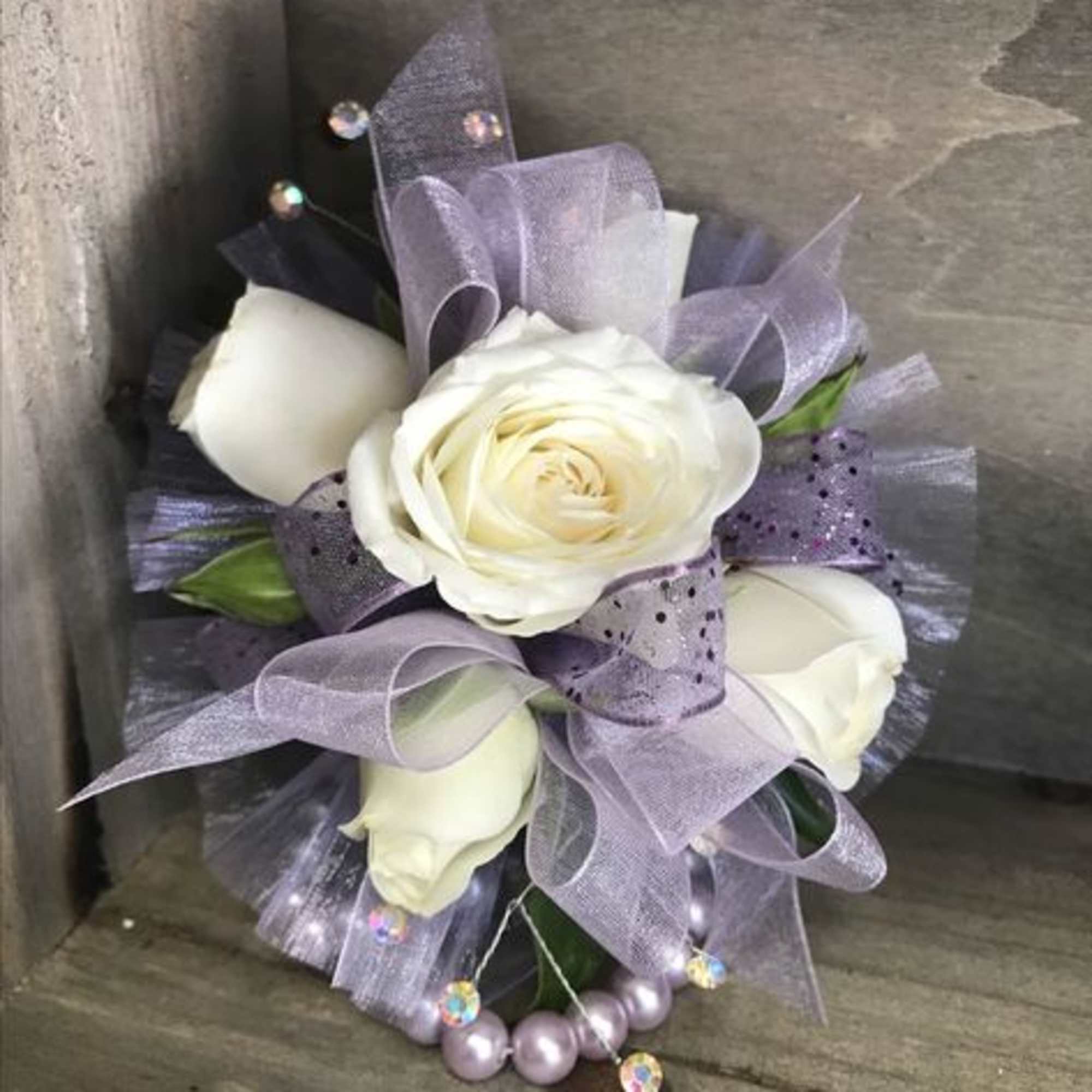 Small bouquet of white roses with lavender ribbon and bead accents