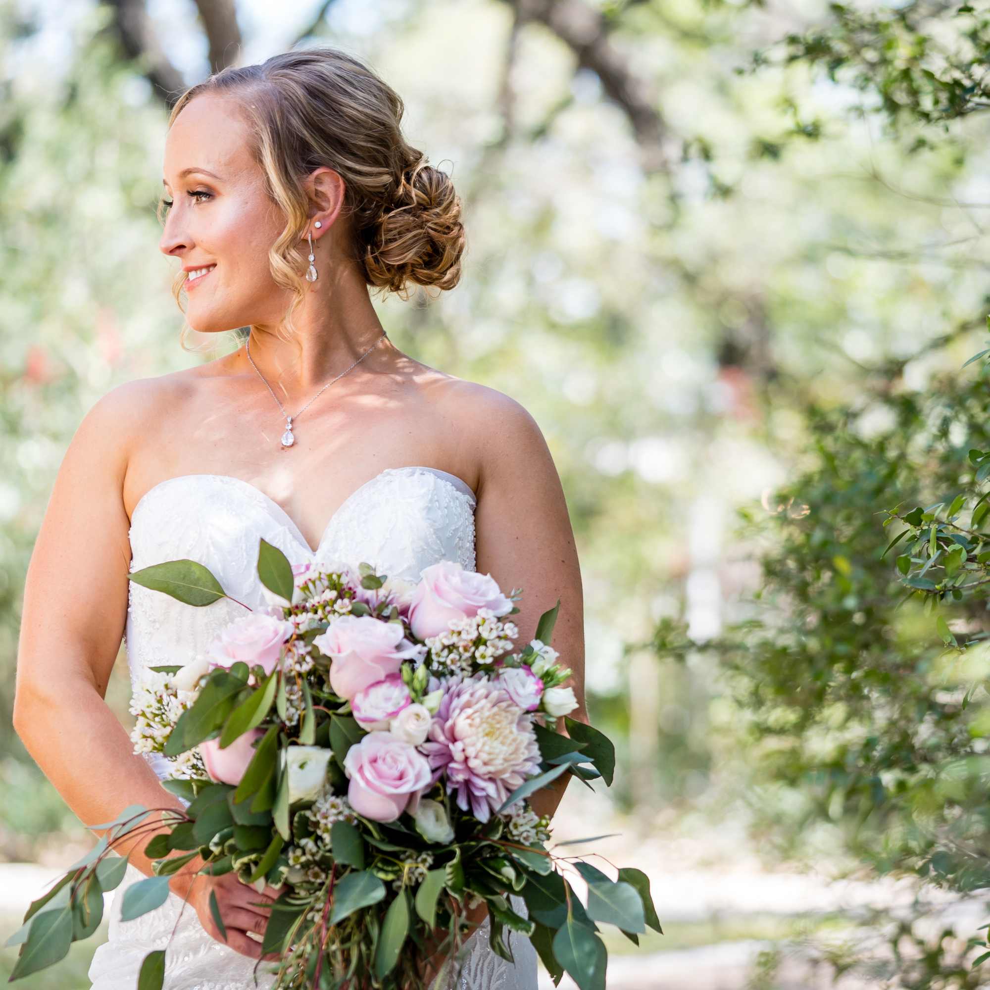 Bride holding a pink and white bouquet outdoors