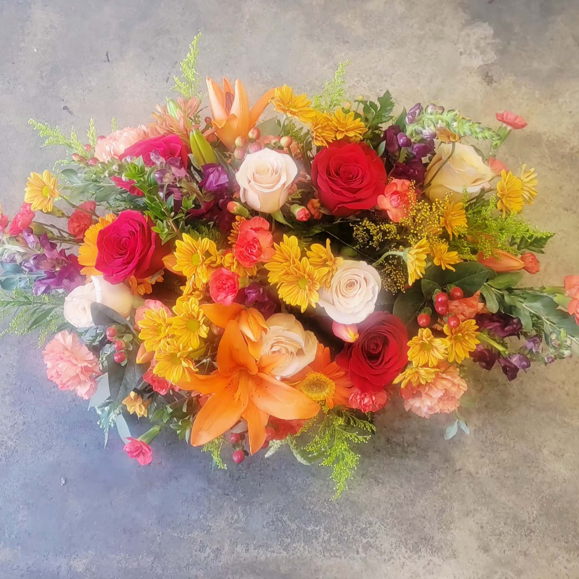 Mixed bouquet of roses, lilies, and yellow daisies in bright colors