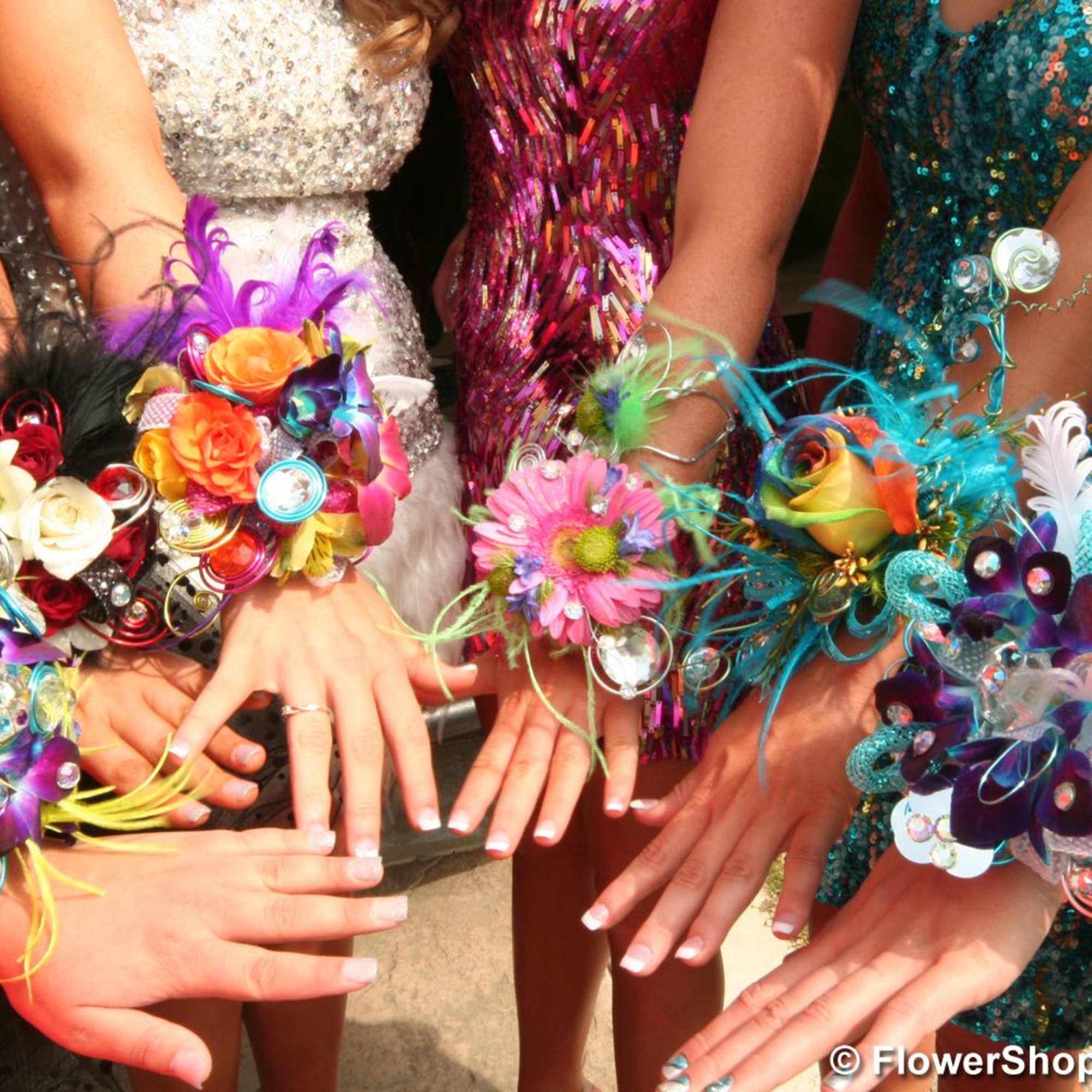 Colorful floral wrist corsages worn by several people