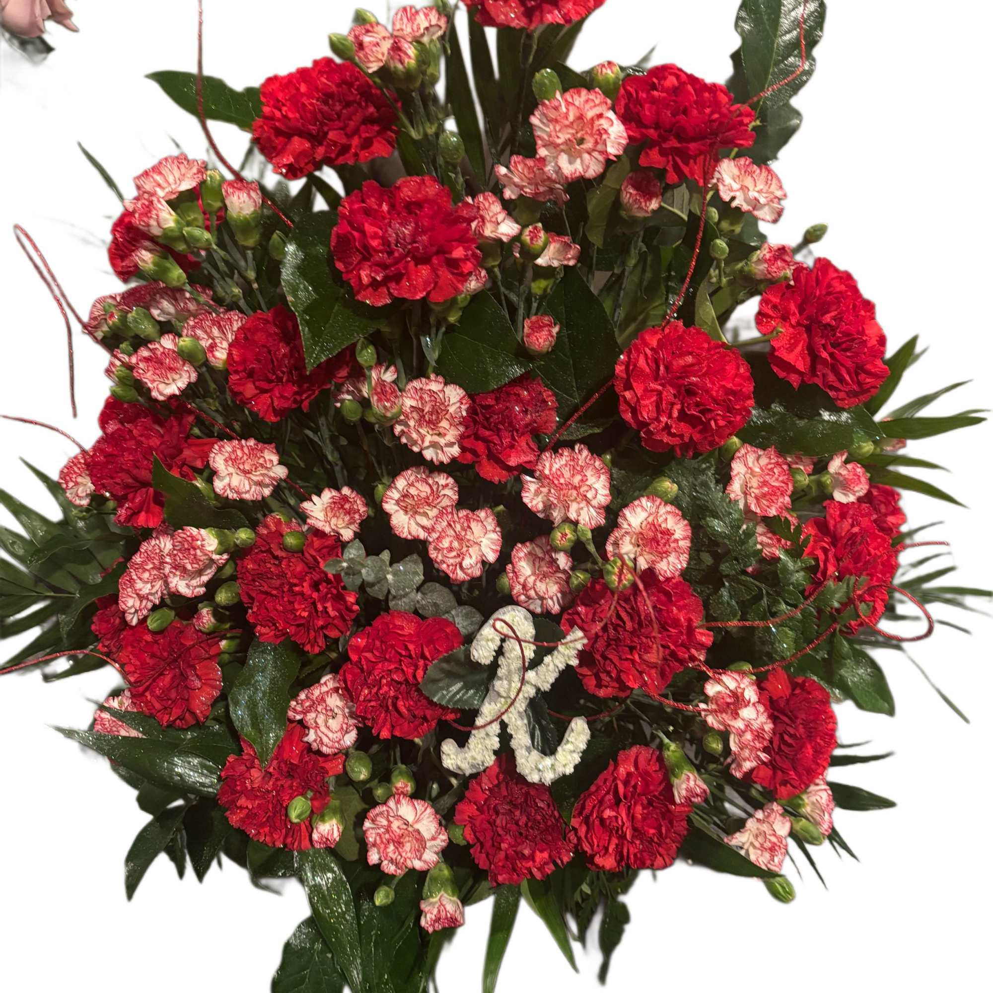 Red and pink carnation arrangement with dark greenery